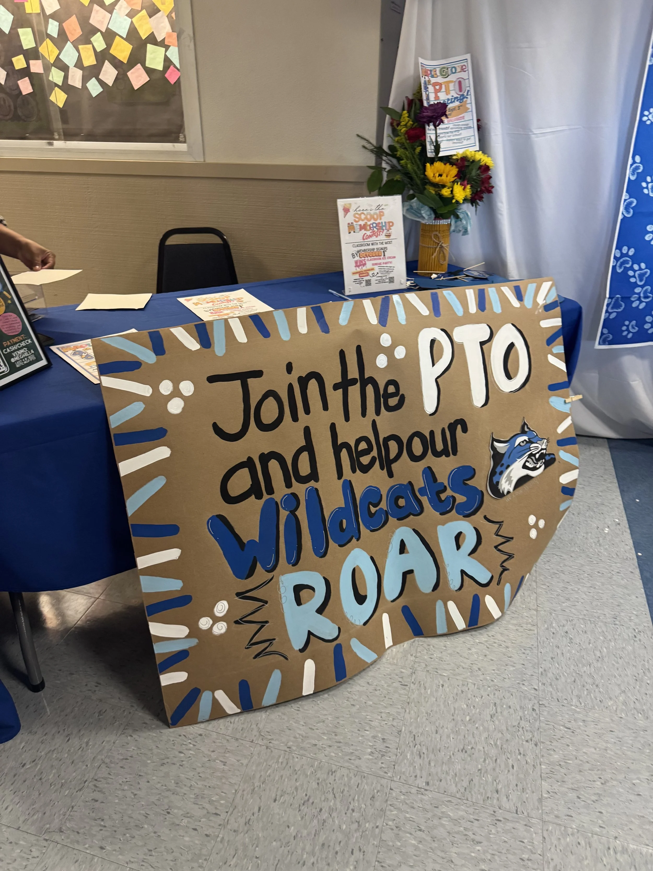 Sign for a PTO event encouraging joining and helping their Wildcats Roar, with decorative blue and white lines and a Wildcats mascot head illustration.