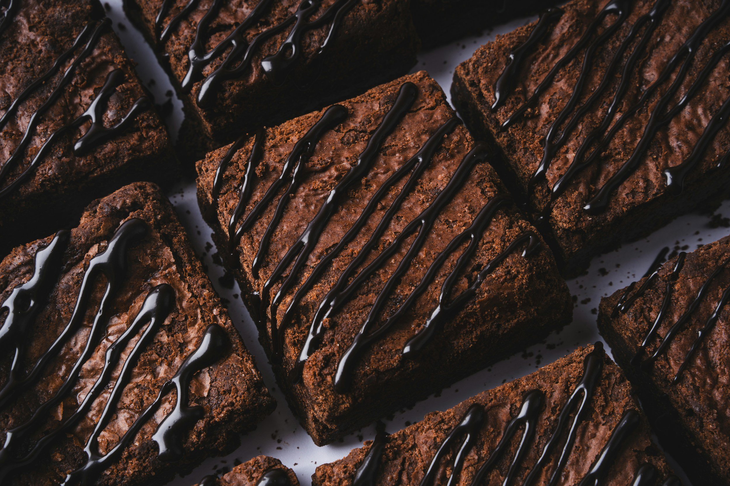 Close-up of chocolate brownies drizzled with dark chocolate.