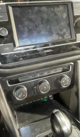 Car dashboard with a large center touchscreen display and climate control dials below