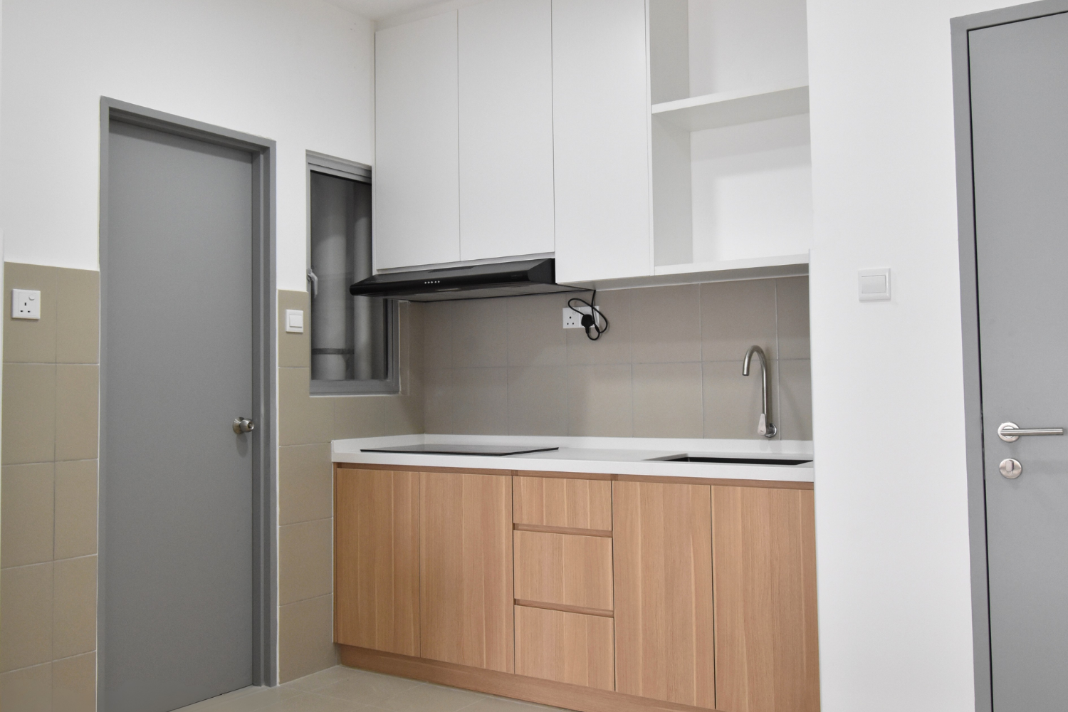 Modern kitchen with beige tiled walls, wooden cabinets, a white countertop, a stainless steel sink, gray doors, and white upper cabinets.