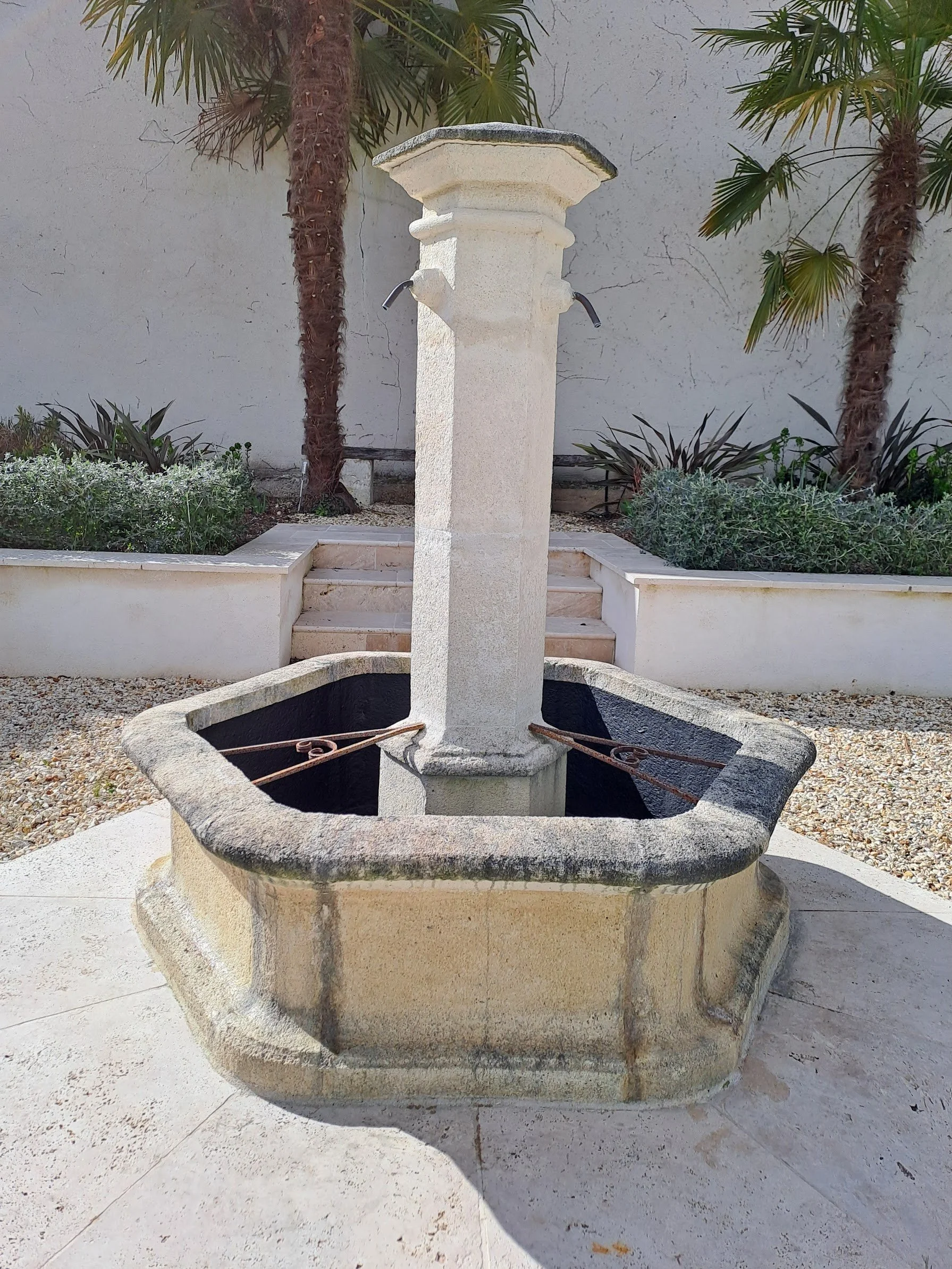 Reclaimed stone fountain in enclosed courtyard garden