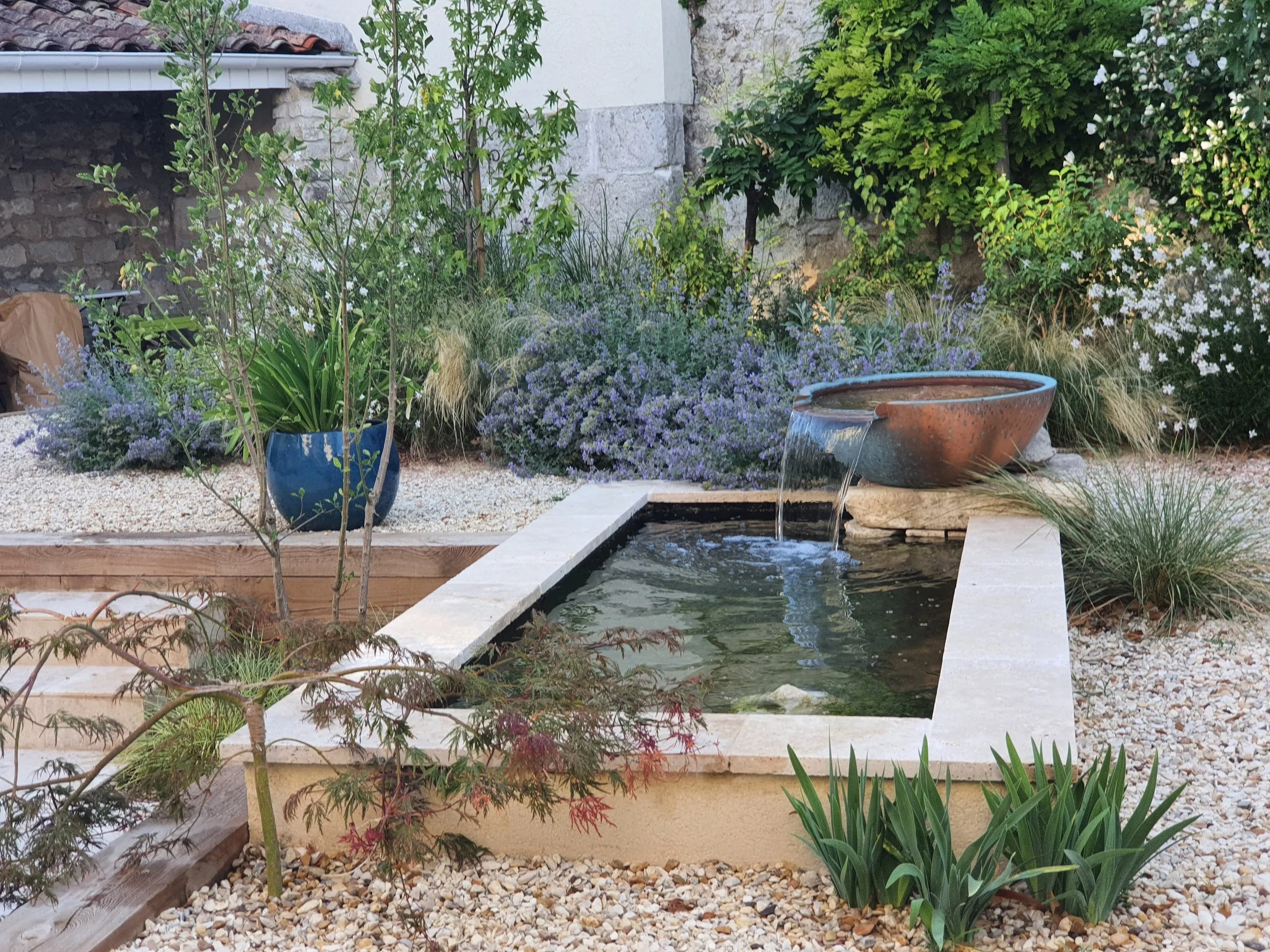 Copper bowl water feature used as a focal point in a contemporary garden design in the Charente
