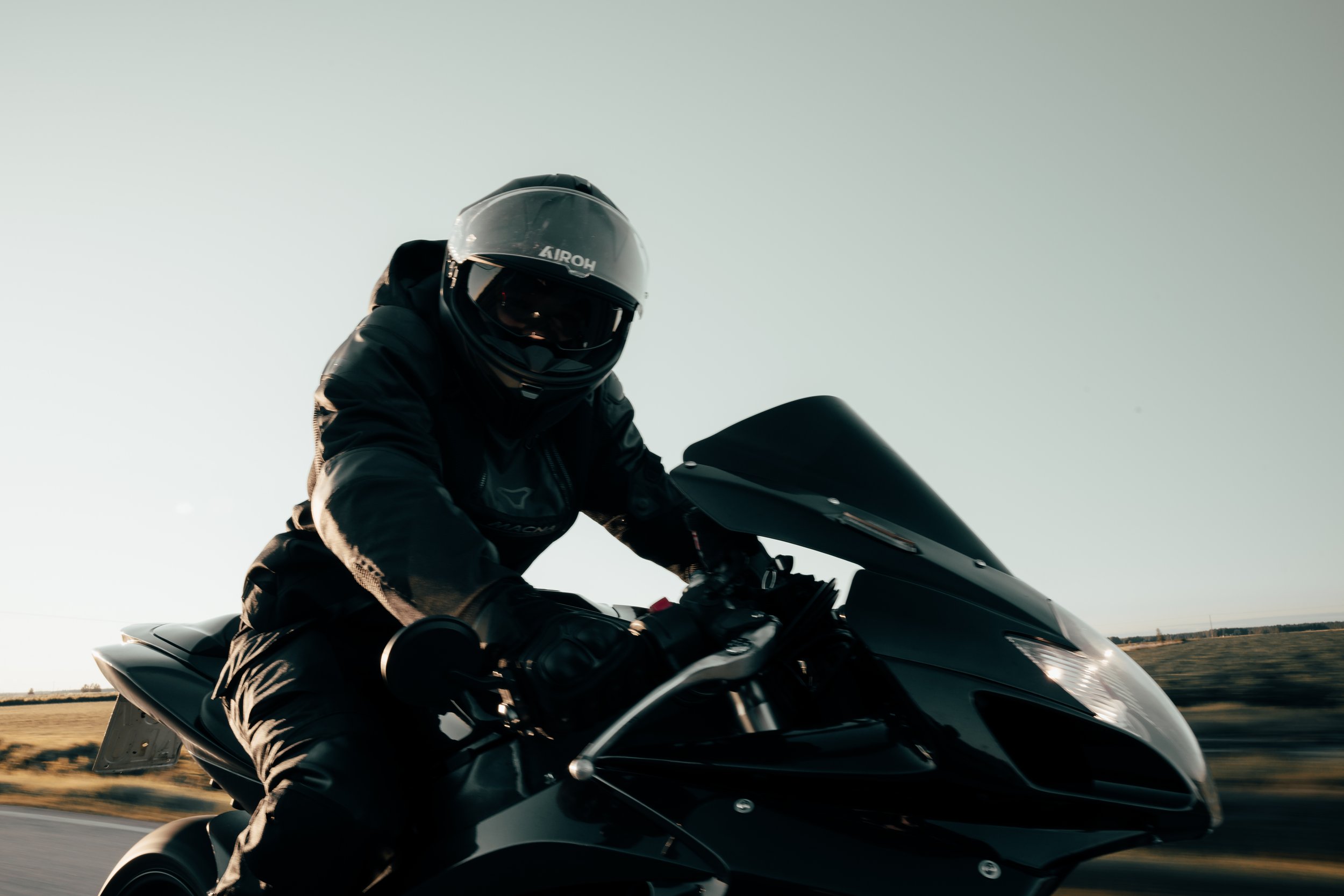 henkilö ajaa moottoripyörällä, wearing a helmet and riding gear