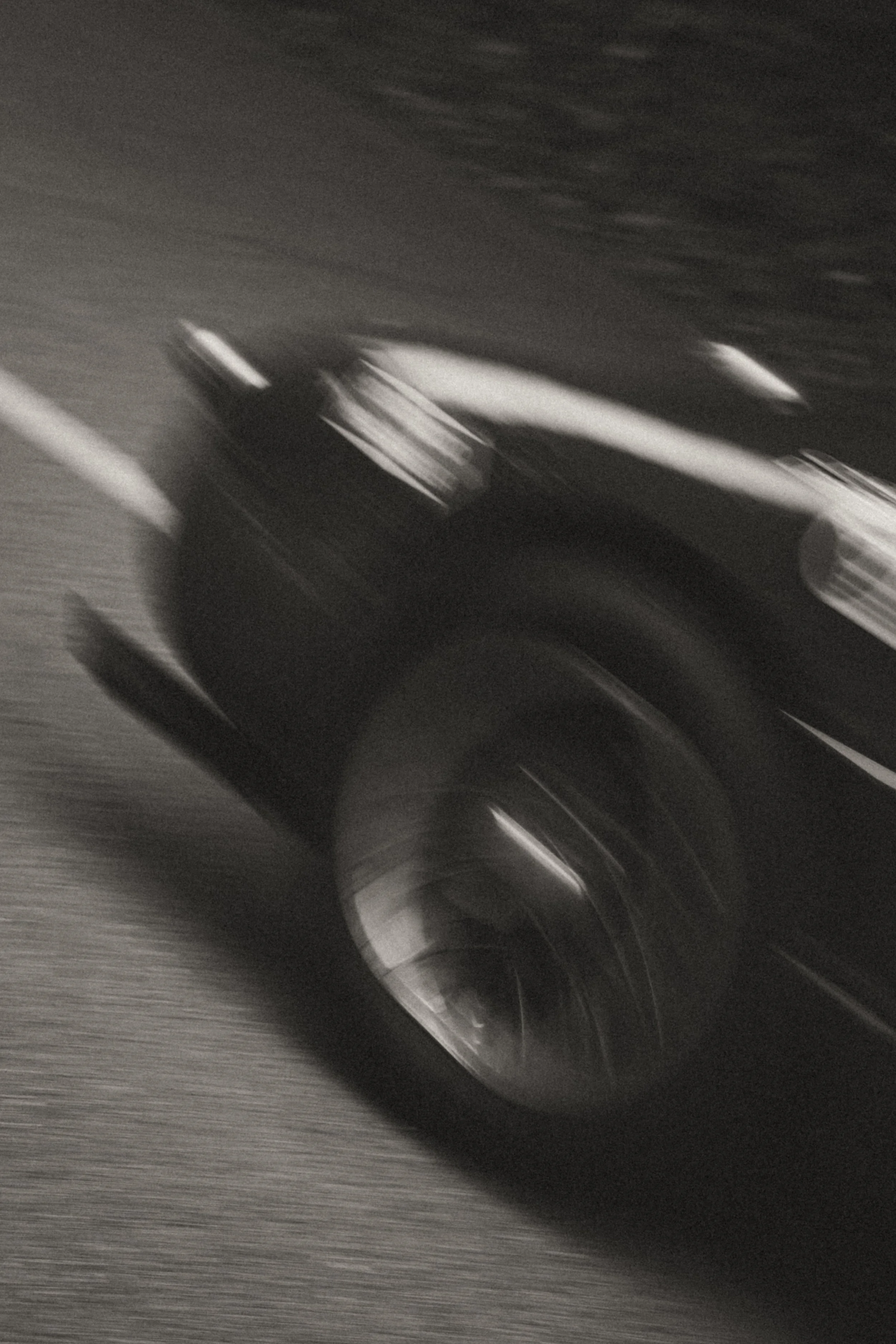 Une photo floue d'une voiture noire en mouvement sur une route, prise de profil.
