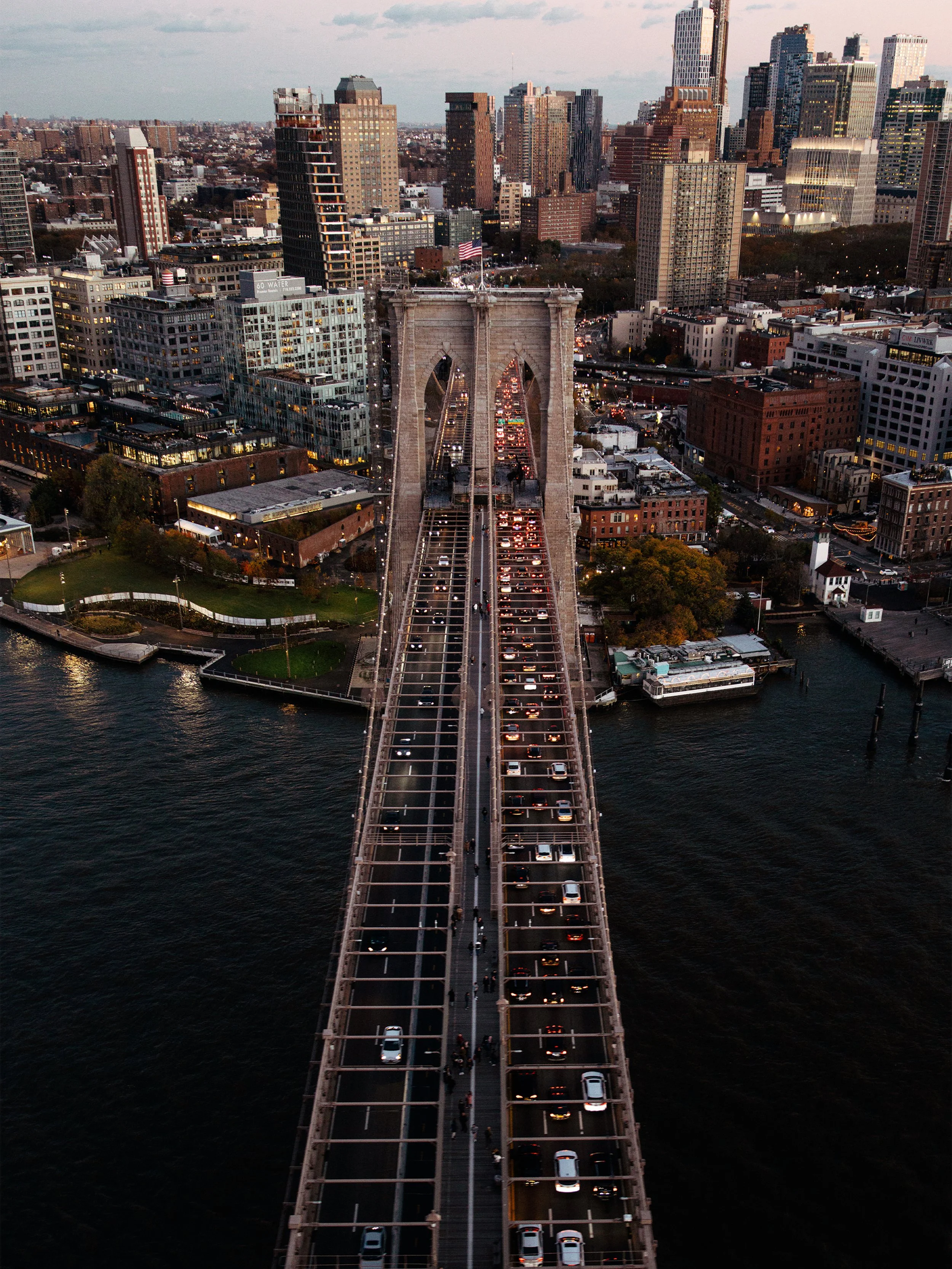 Vue aérienne du pont de Brooklyn avec trafic, sur la rivière, avec la skyline de New York au coucher du soleil.