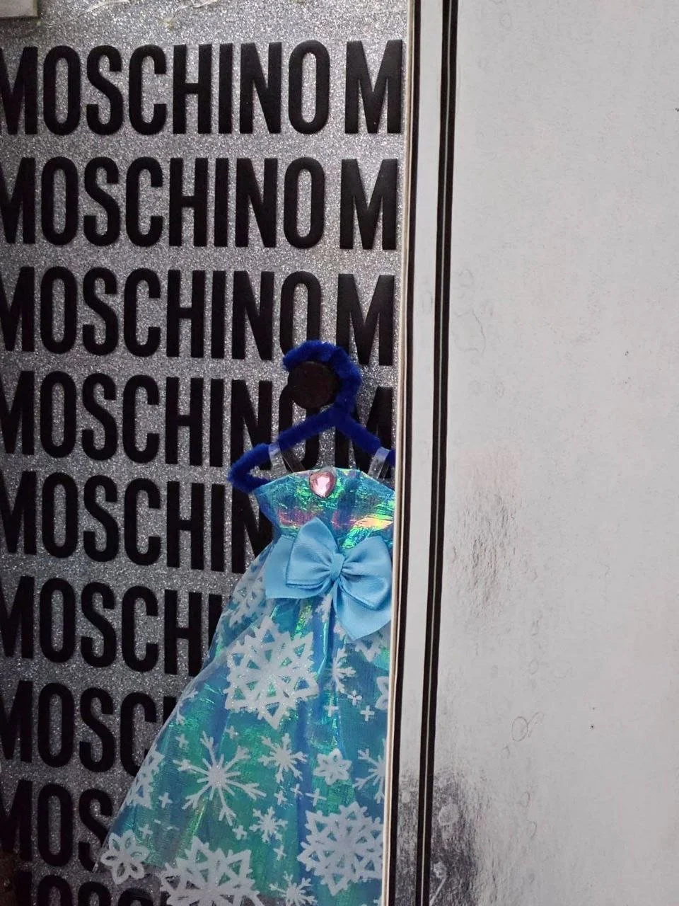 Integrated lighting was positioned along the sides of the structure to frame the garment and enhance depth, directing attention toward the centre while amplifying the playful yet curated Moschino aesthetic.