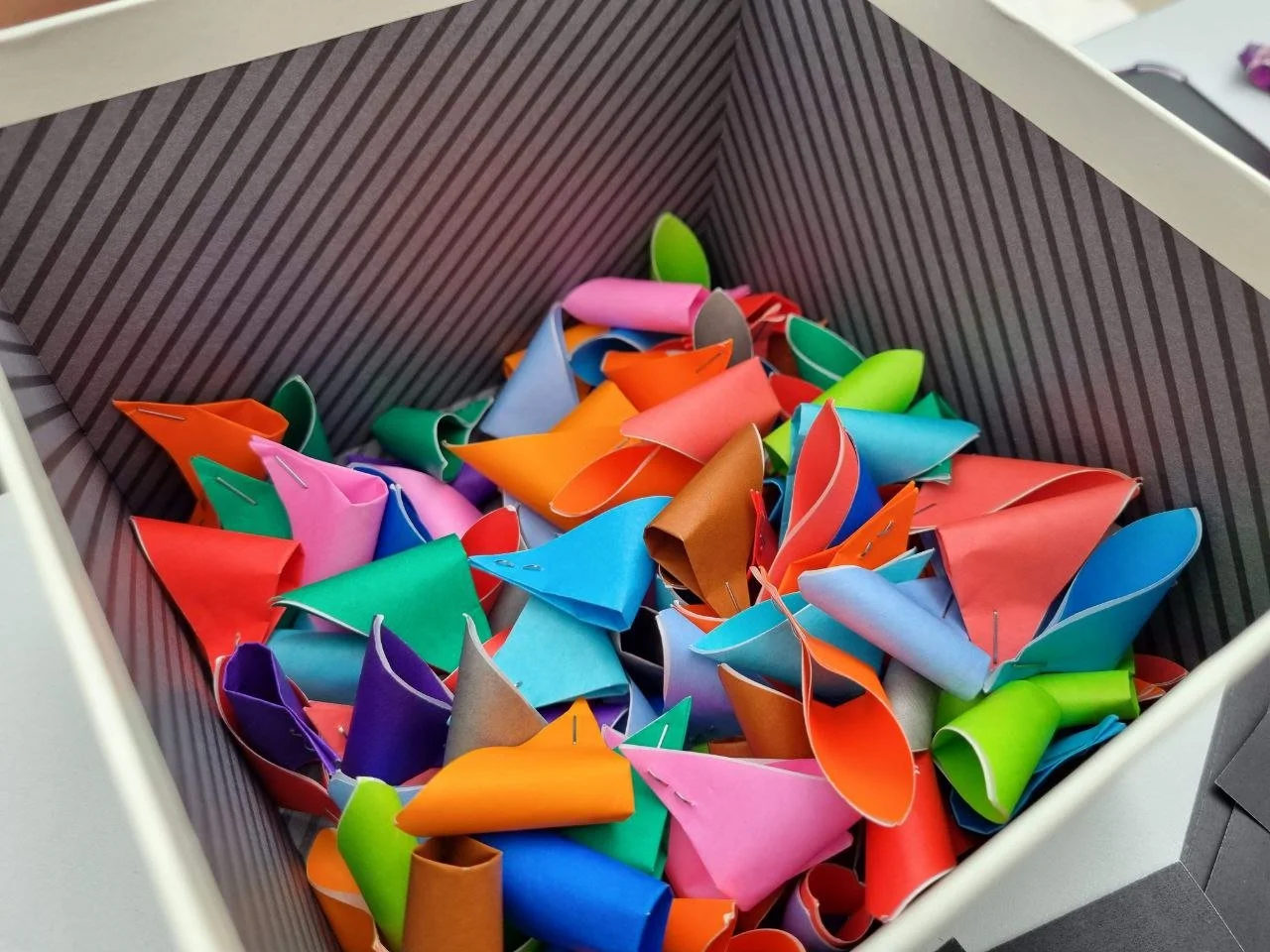 The colourful paper elements were used as part of the interactive system, adding a playful visual contrast while guiding participants through the activity. Bright colours helped draw attention to the booth and encouraged participation, especially fro