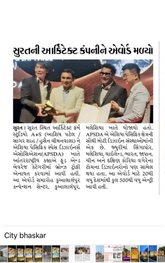 Four men in suits smiling and exchanging a trophy and a document on stage at an award ceremony.