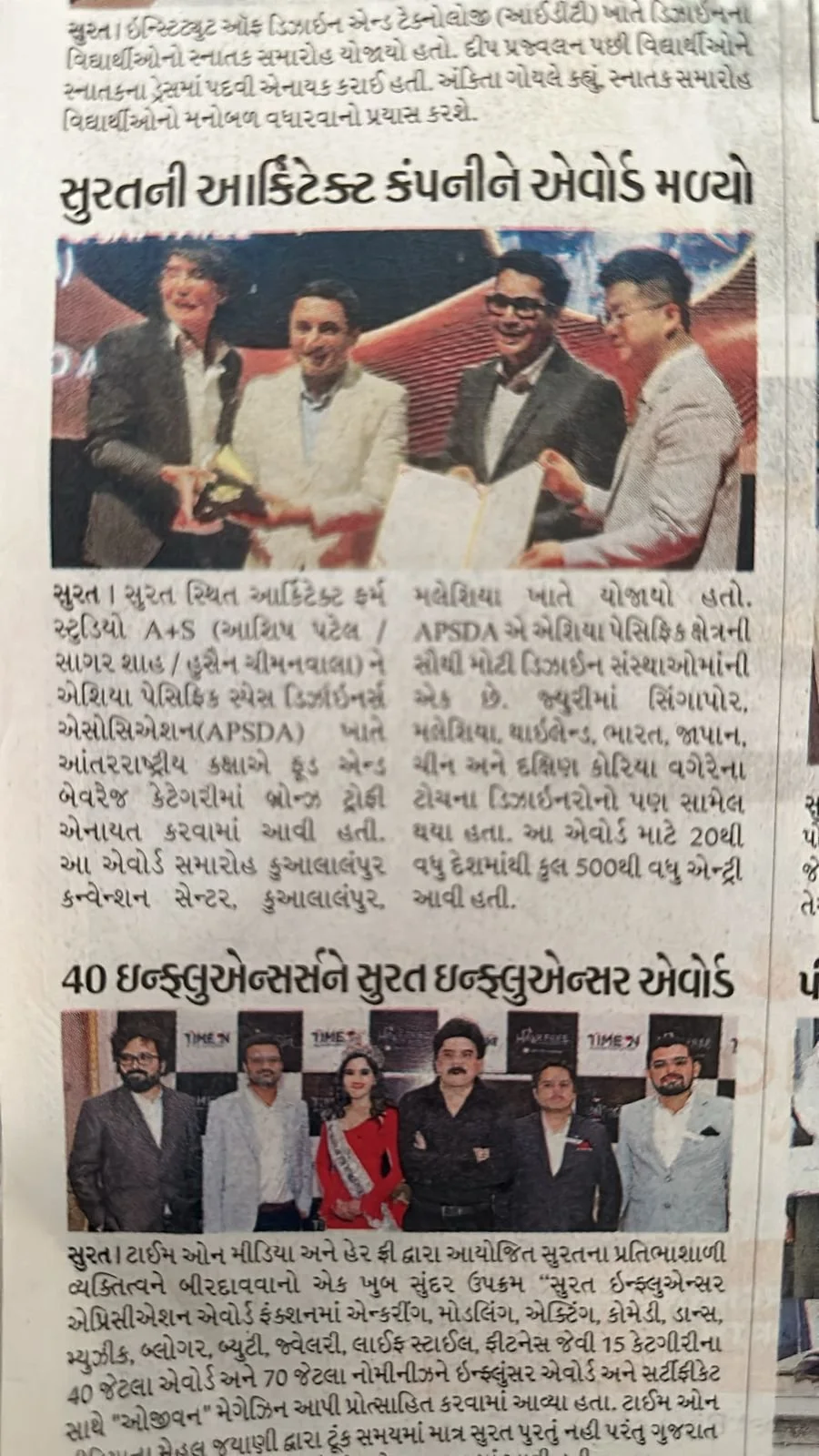 Group of four men in suits shaking hands and exchanging a document at a formal event.