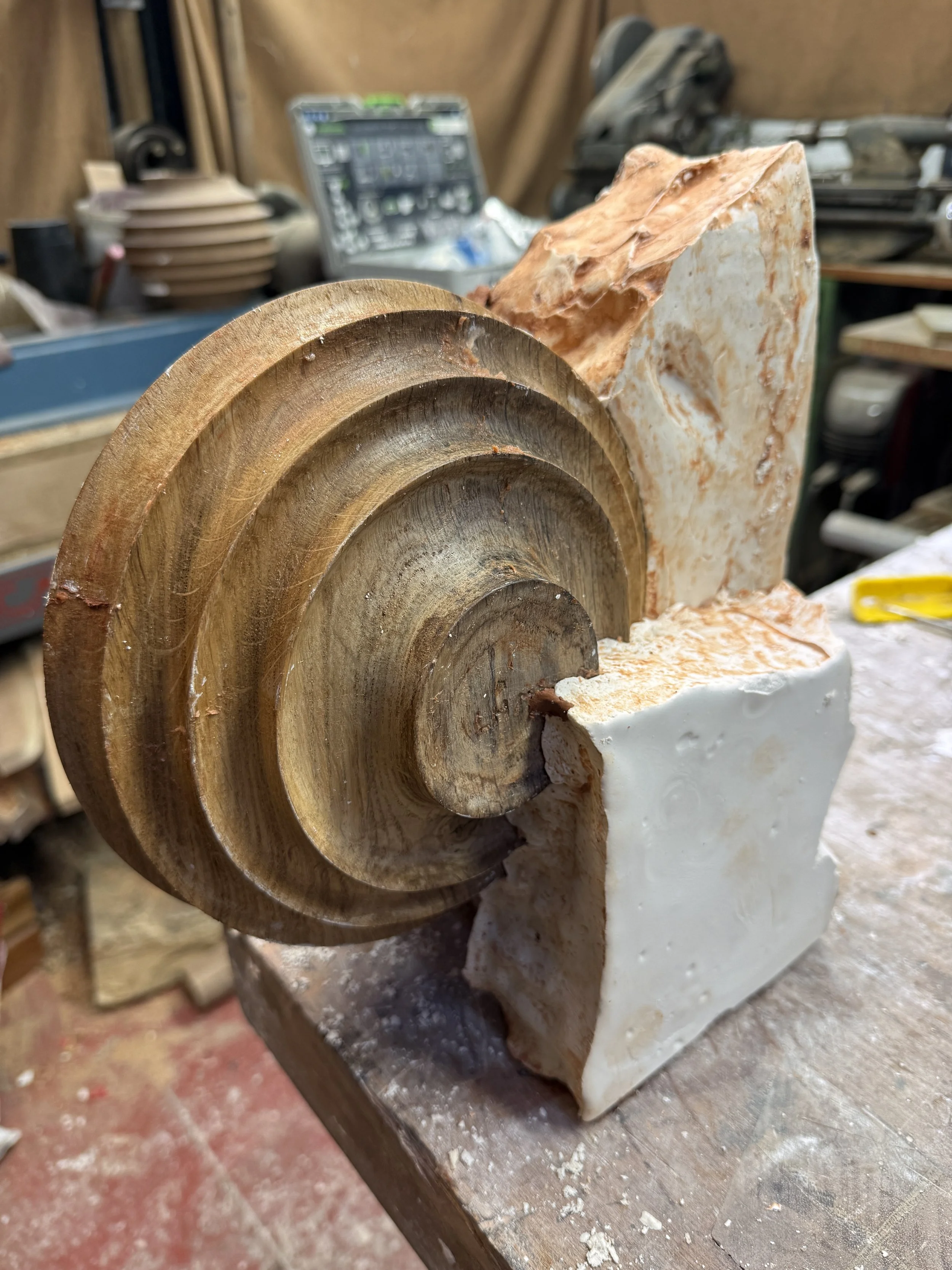 Une sculpture en bois et en pierre en cours de fabrication dans un atelier de menuiserie