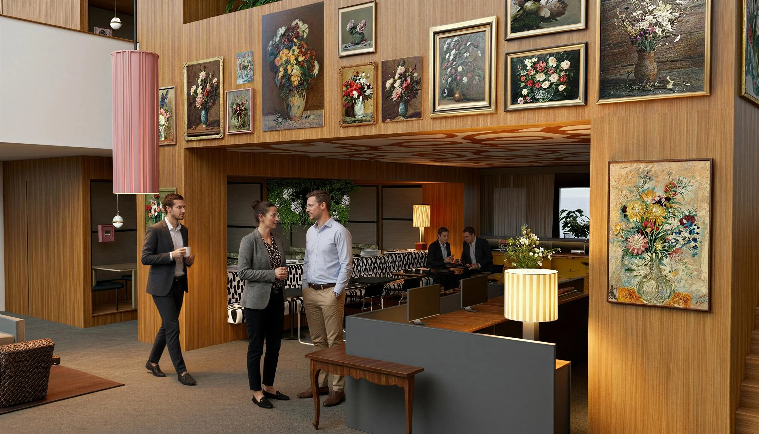 Inside a modern office with wooden walls and numerous floral paintings hanging. Four people are standing and conversing in the foreground, while more people are seated at a table in the background.