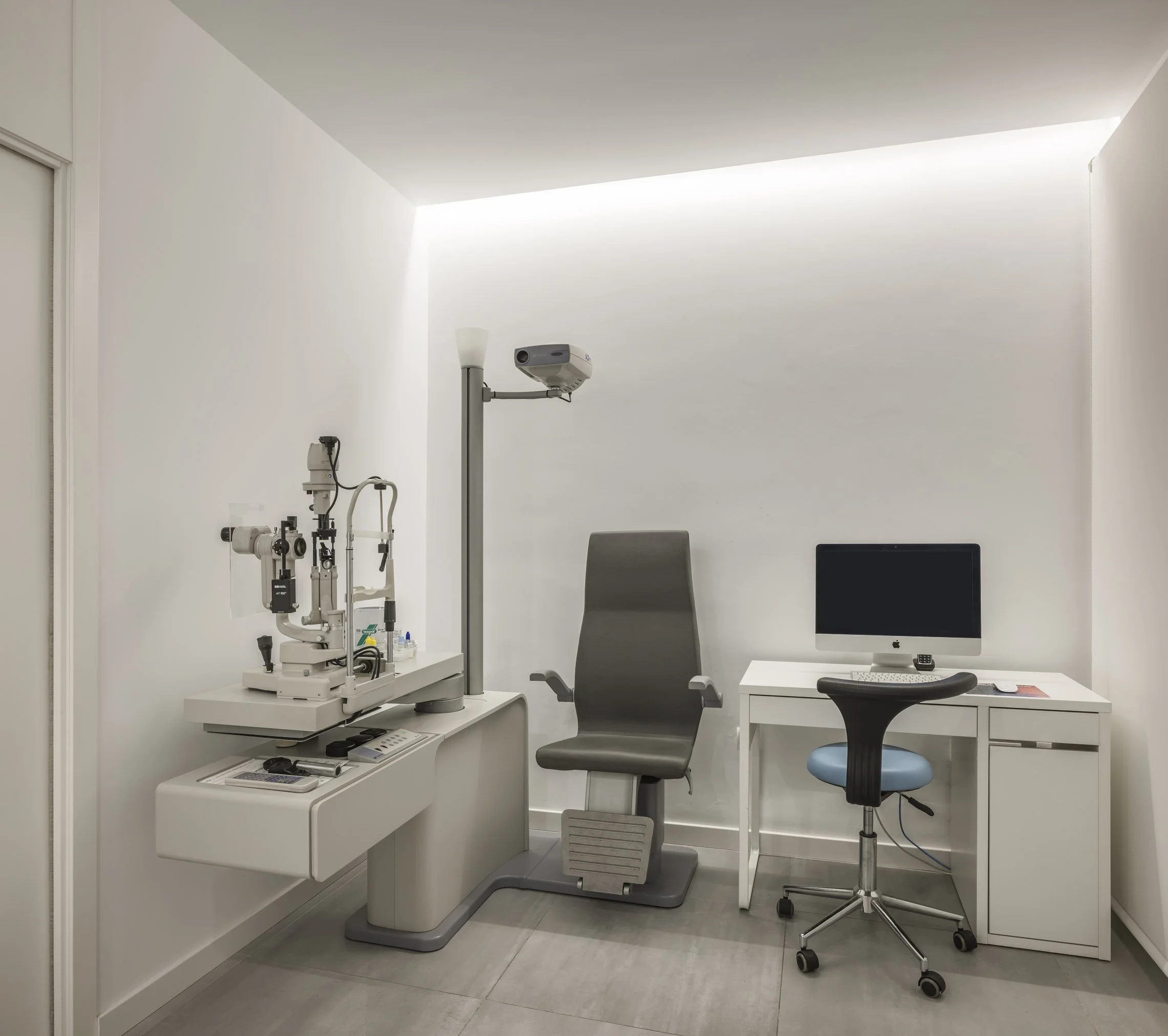 Consulta médica con equipo óptico y computadora en consulta de clínica.