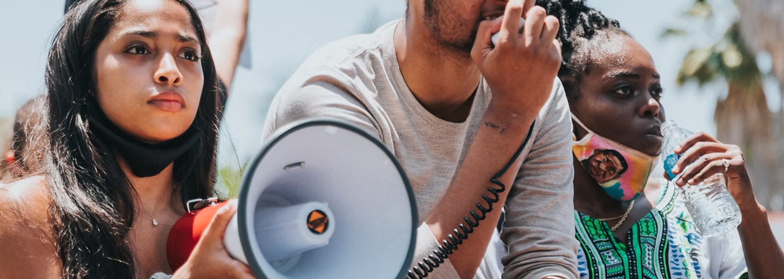 Young people with a loudspeaker at a protest