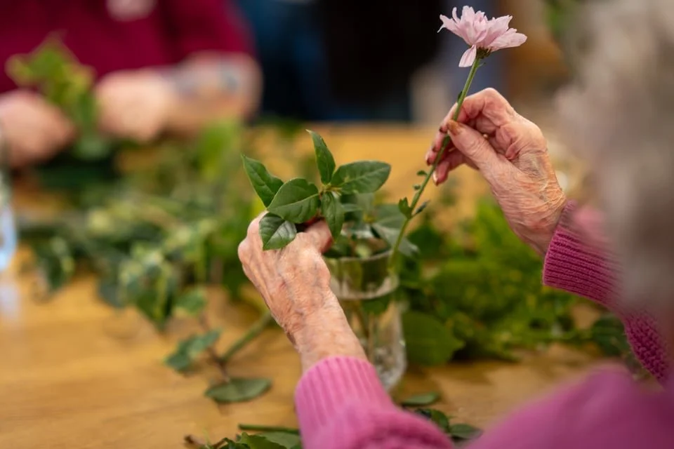 residents flower arranging in care home