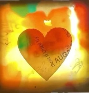 A paper heart with printed text, placed against a bright, multicolored, abstract background.