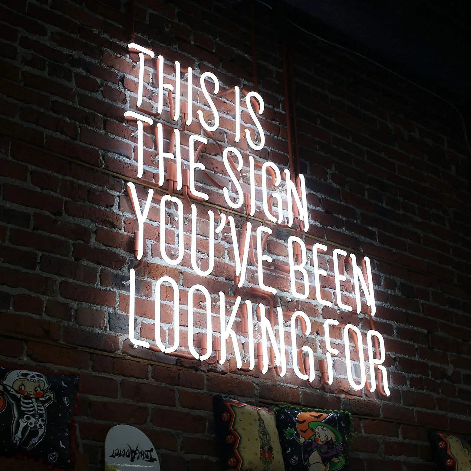 Neon sign on brick wall reads: 'This is the sign you’ve been looking for.'