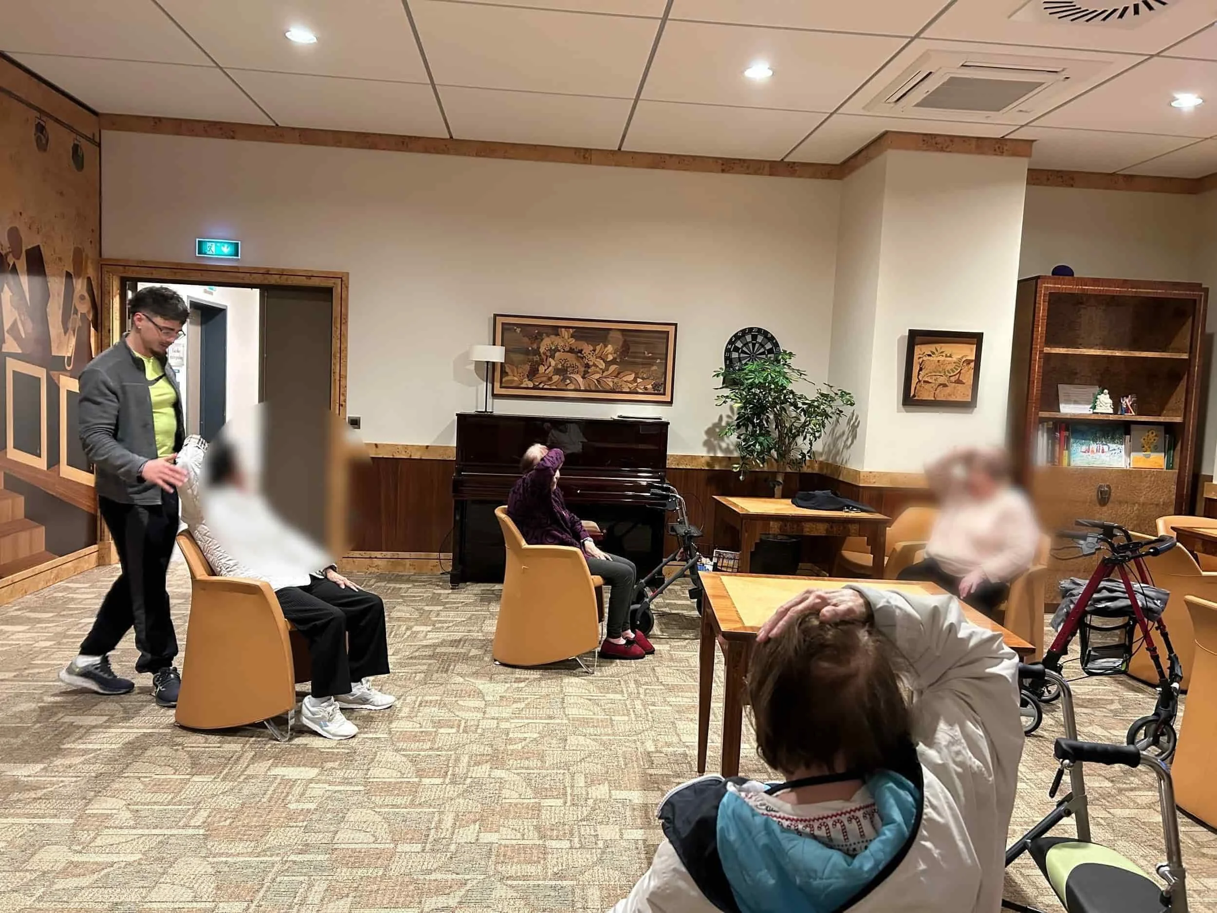 Coach sportif guidant des seniors lors d’une séance d’exercices en résidence, favorisant la mobilité, la santé et le bien-être des personnes âgées.