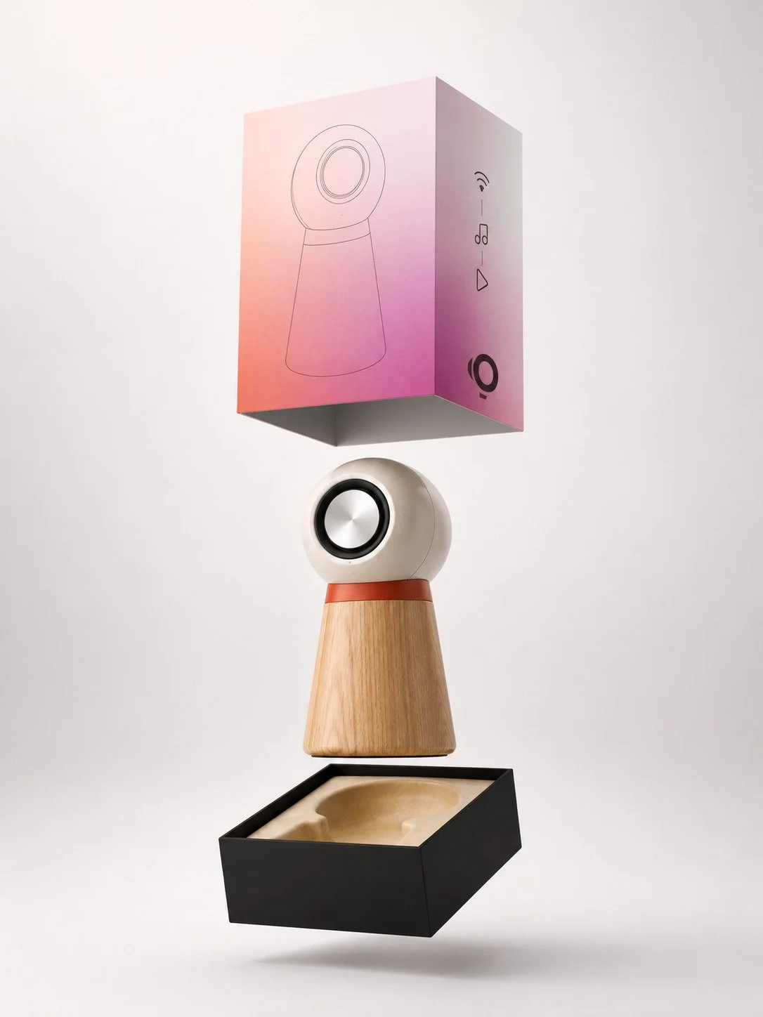 A product packaging box, a spherical speaker, a wooden stand, and a black tray arranged in a vertical line, with the box at the top and the tray at the bottom.