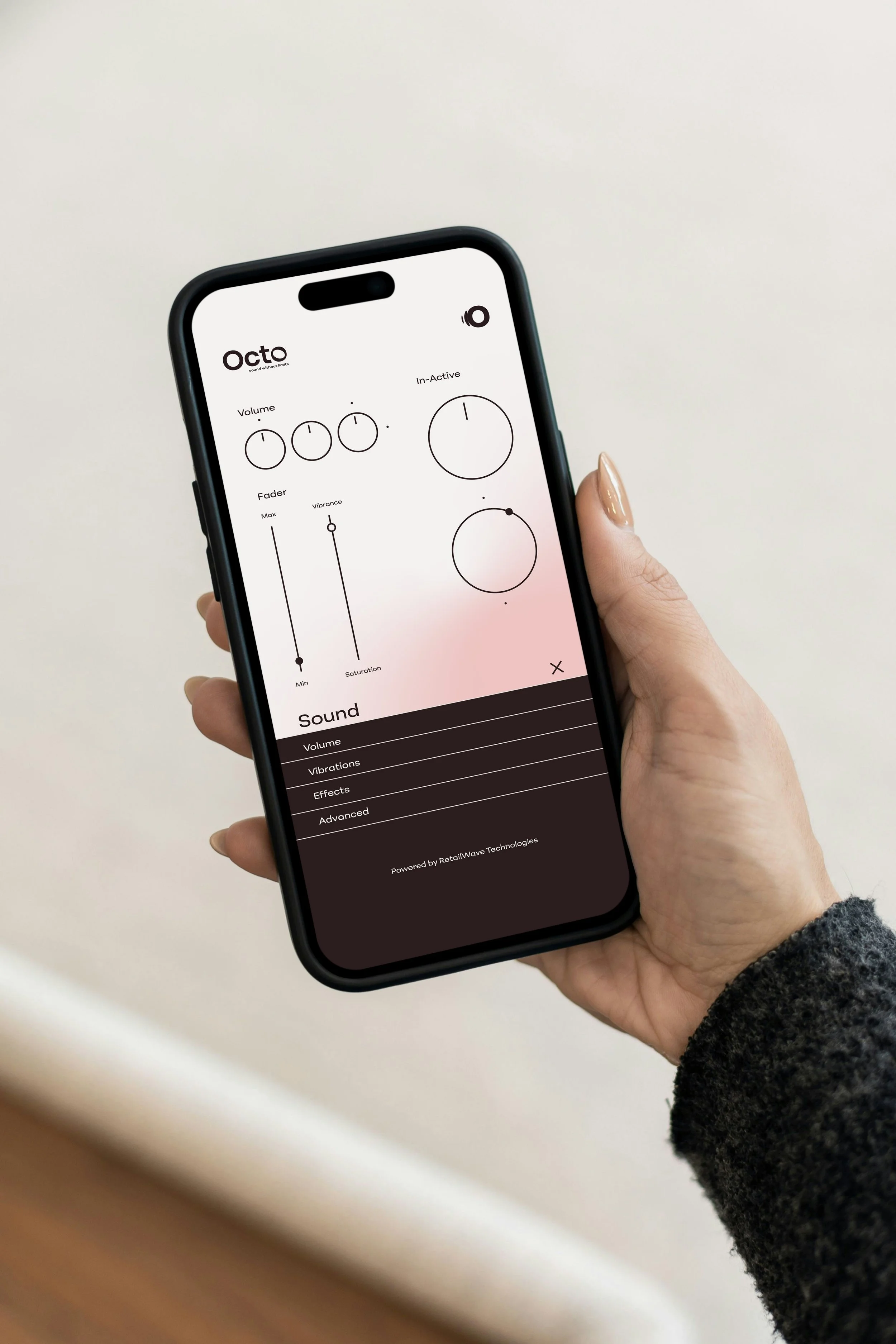 A person holding a smartphone showing an audio editing app with various controls and sliders, against a plain light background.