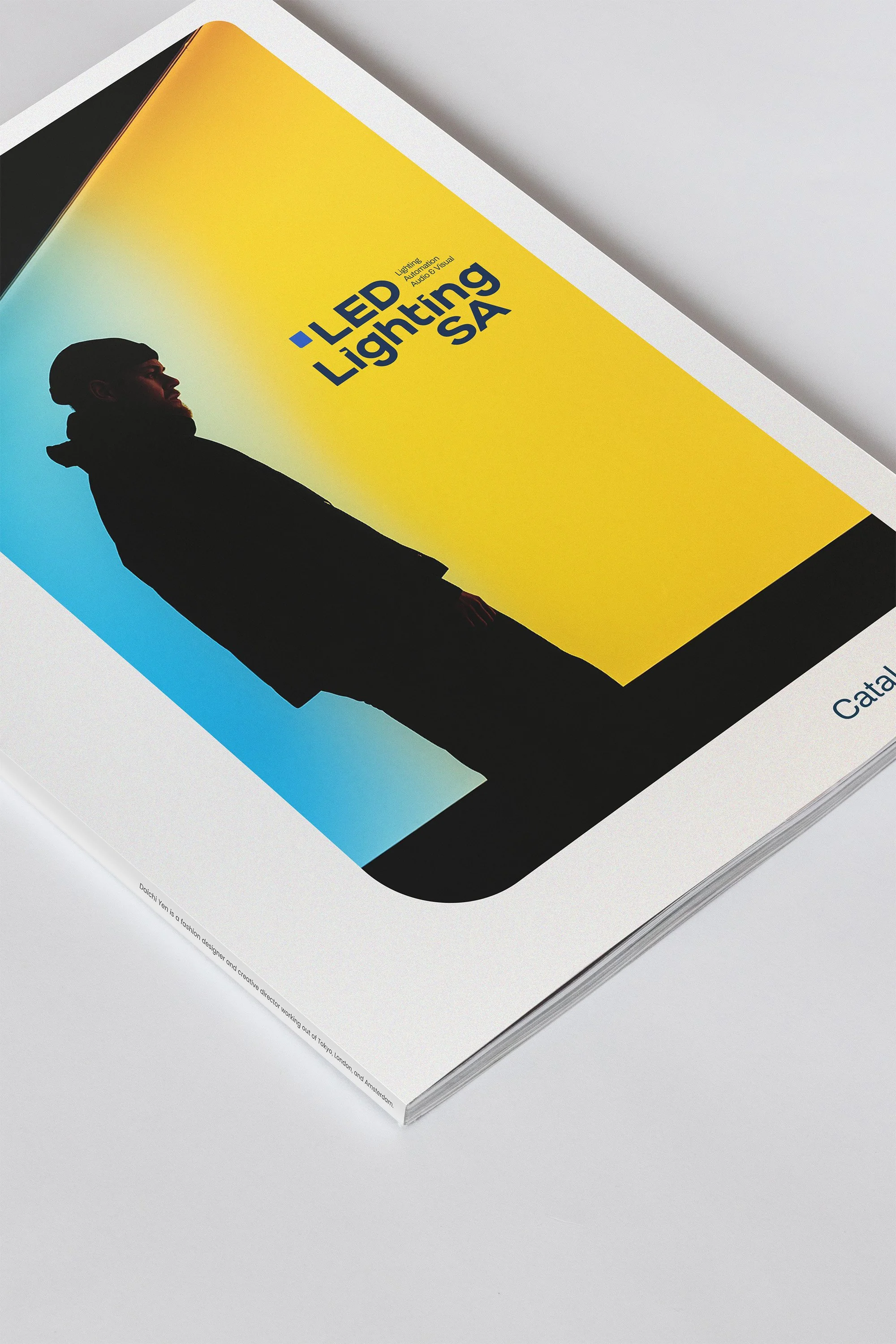 A catalog cover with a silhouette of a person standing against a background split into yellow and blue sections. The cover features the text 'LED Lighting SA' in bold blue letters.