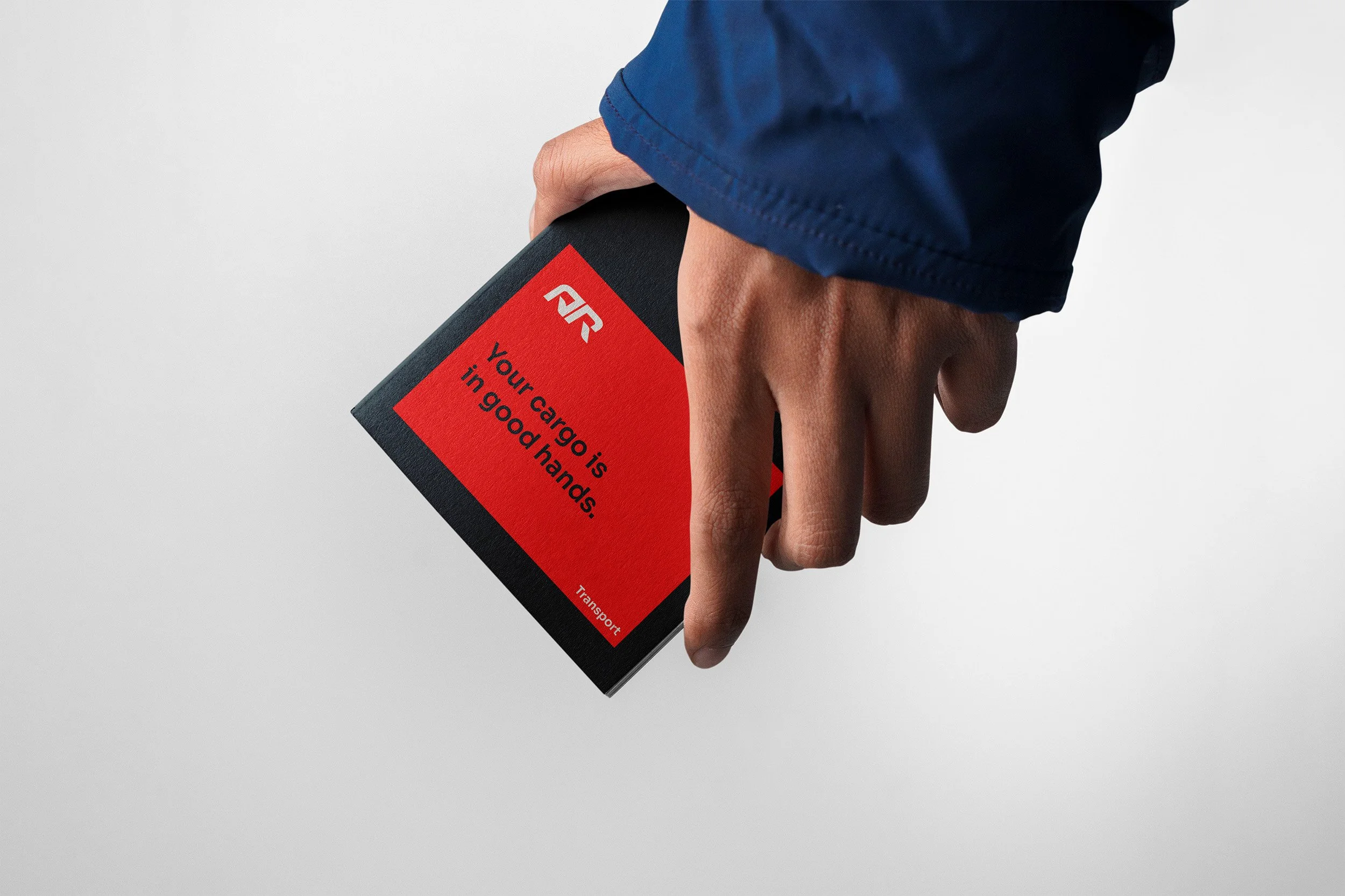 Person holding a red and black transport card with the message 'Your cargo is in good hands' printed on it.