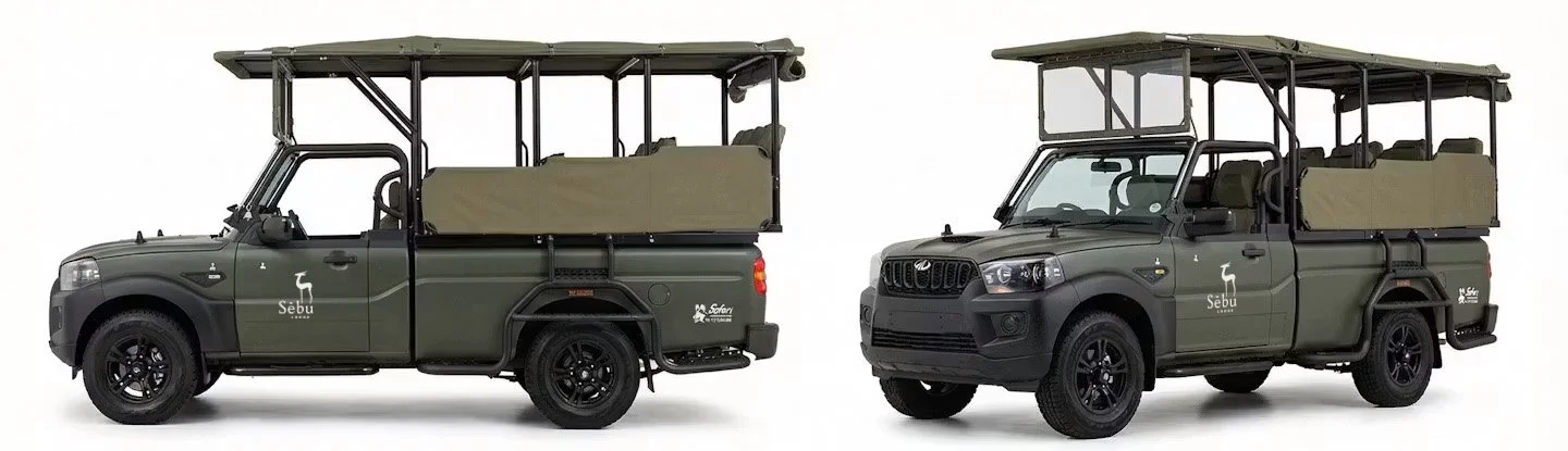Two dark green safari vehicles with open sides and roofs, each with seating in the back, featuring a white 'Sebu' logo on the doors and a small penguin icon. The vehicles have black wheels, and the first vehicle has a canvas cover over the back seats, while the second has a more enclosed canopy.