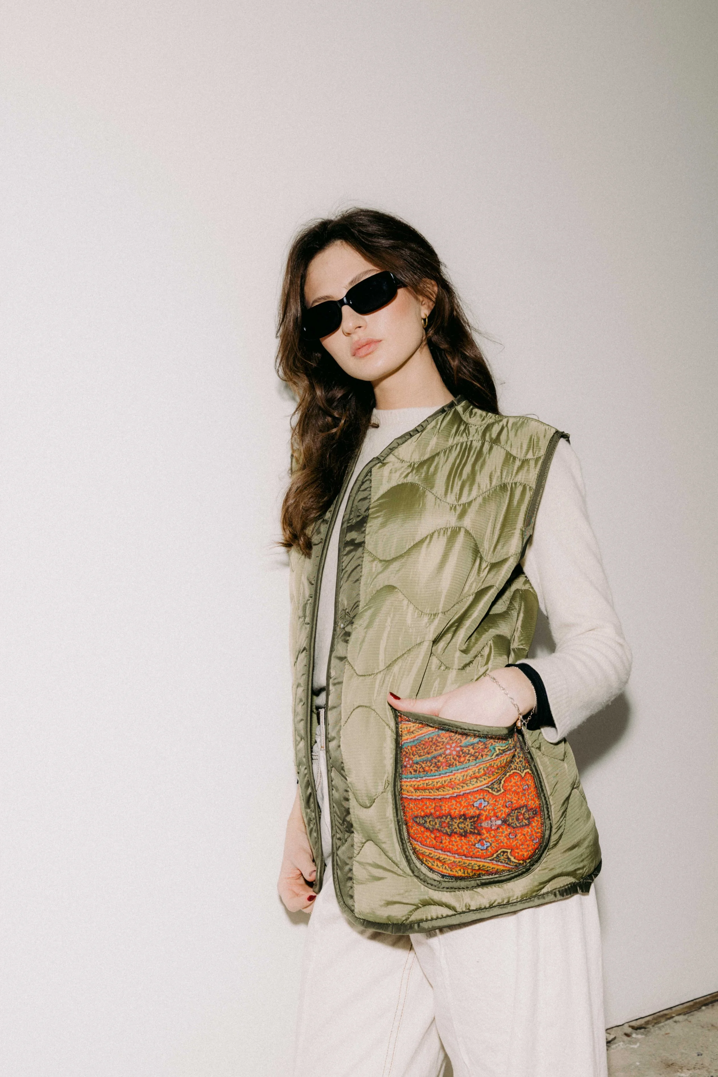 Smanicato liner Bellini trapuntato in tessuto tecnico verde, indossato all’aperto come capo intermedio.