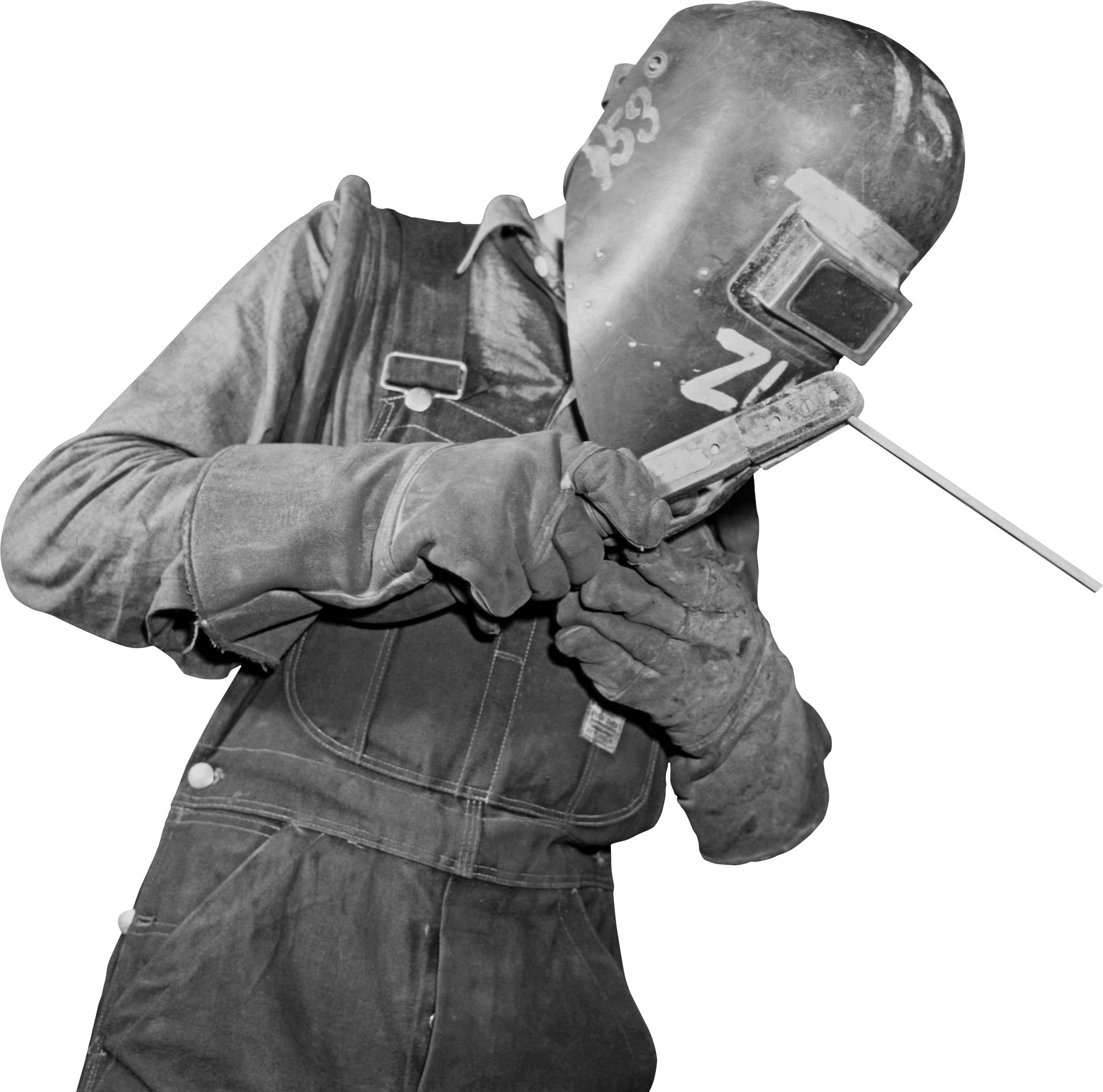 A welder wearing a protective welding mask, gloves, and overalls, using a welding tool.