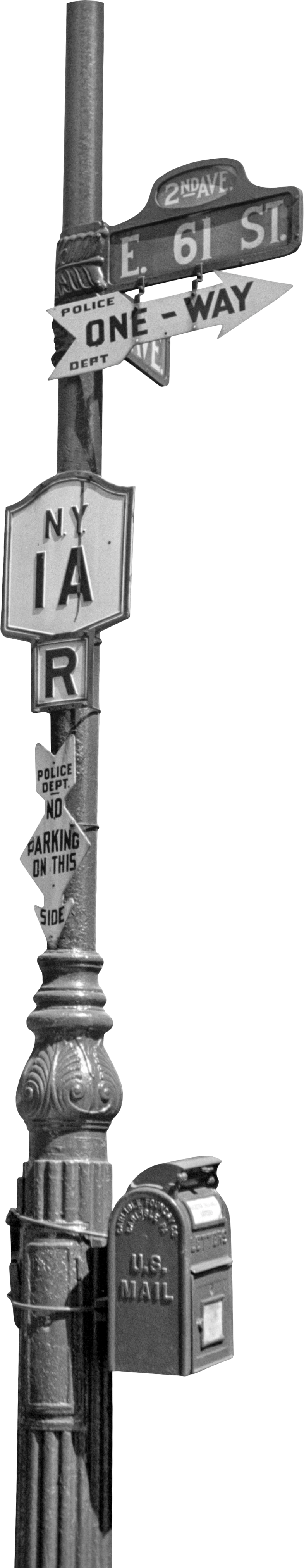 A street corner signpost with street signs, a one-way sign, a police department notice, and a U.S. mail drop box attached to a decorative pole.