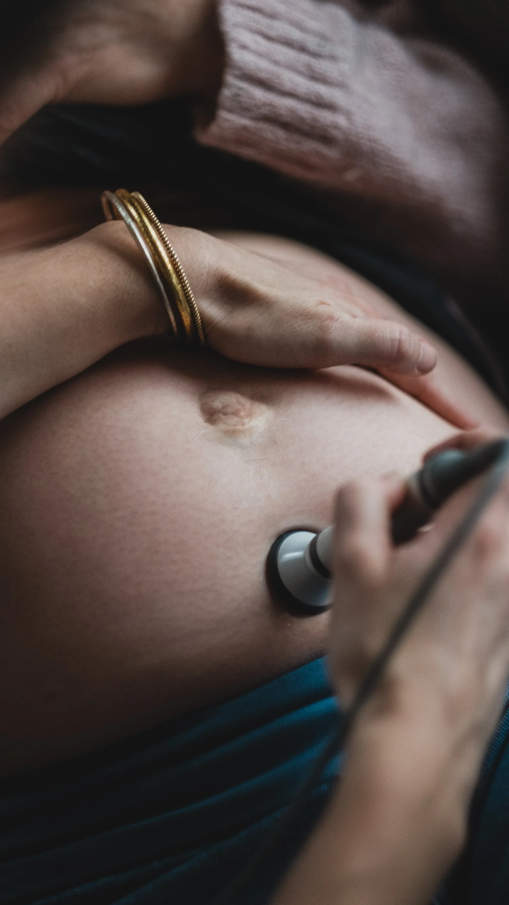 Person performing an ultrasound on another person's abdomen.