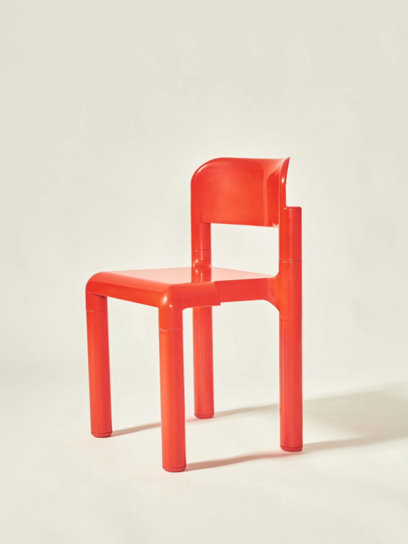 Red plastic chair against a plain background.