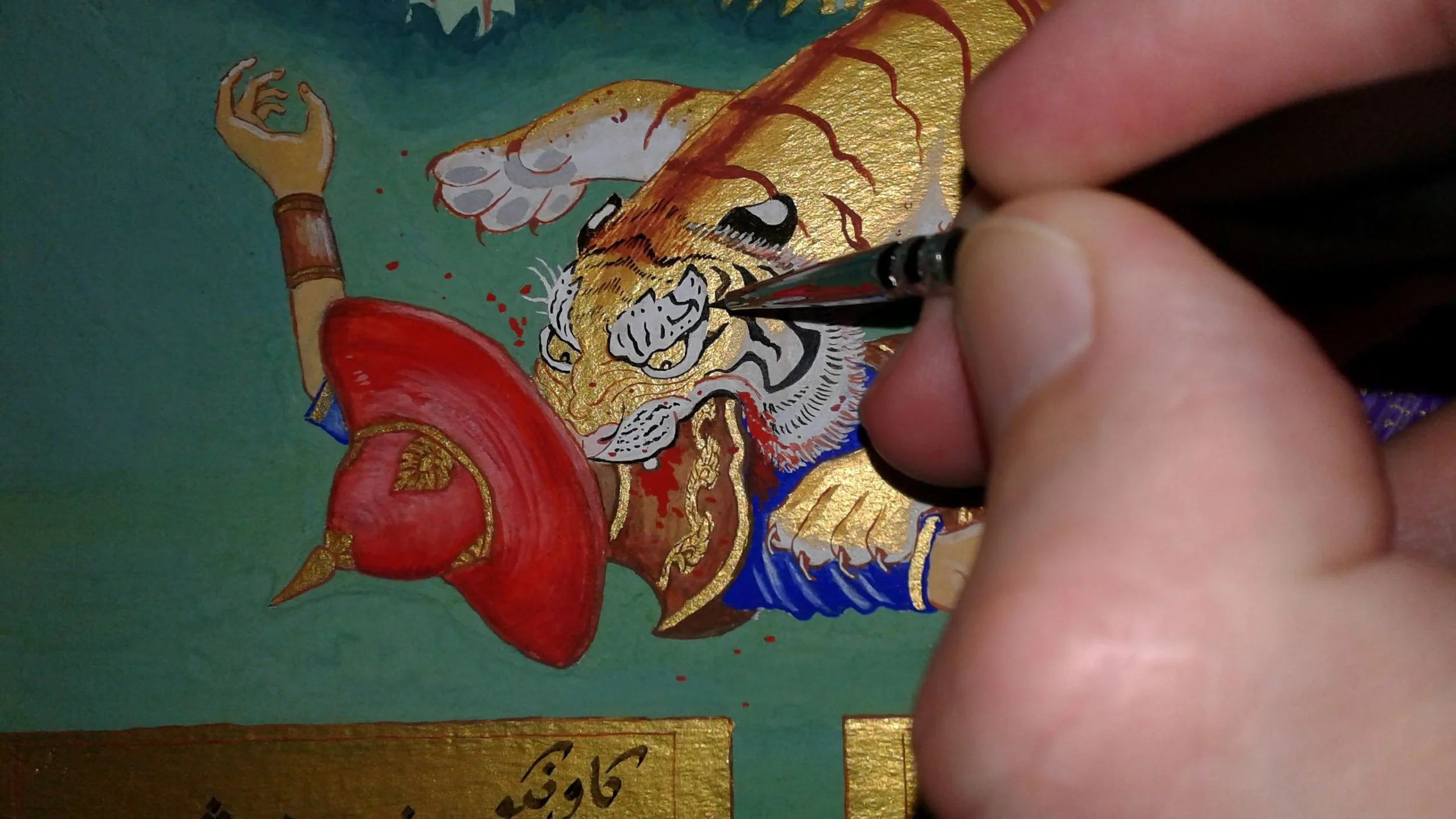 Adding the final details to a painting inspired by Tipoo Sultan's infamous toy of a tiger attacking a British soldier.