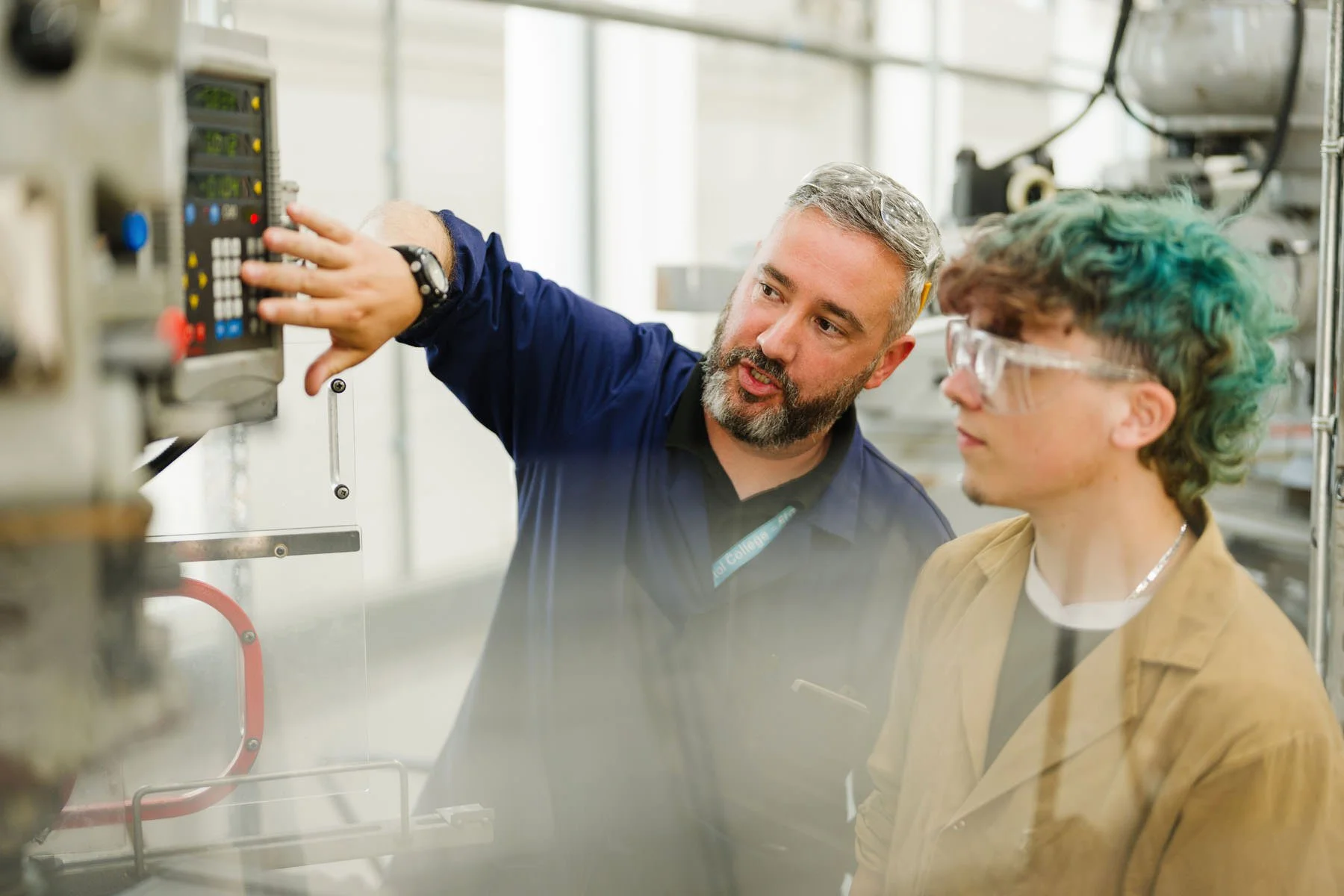 Two men in a laboratory, one demonstrating a piece of equipment to the other.