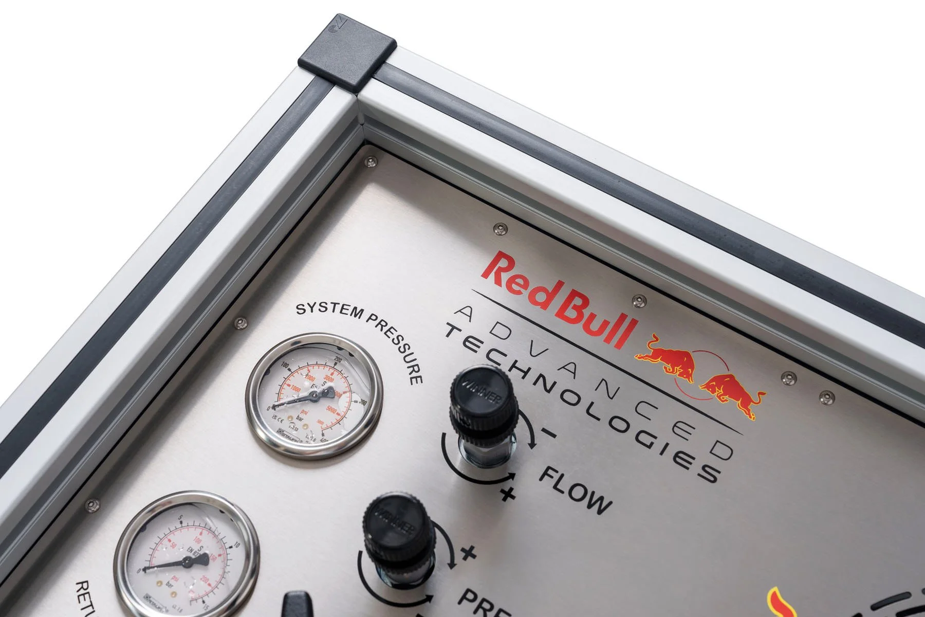 Close-up of a Red Bull branded advanced automotive technology system panel with gauges, knobs, and black corner protectors.