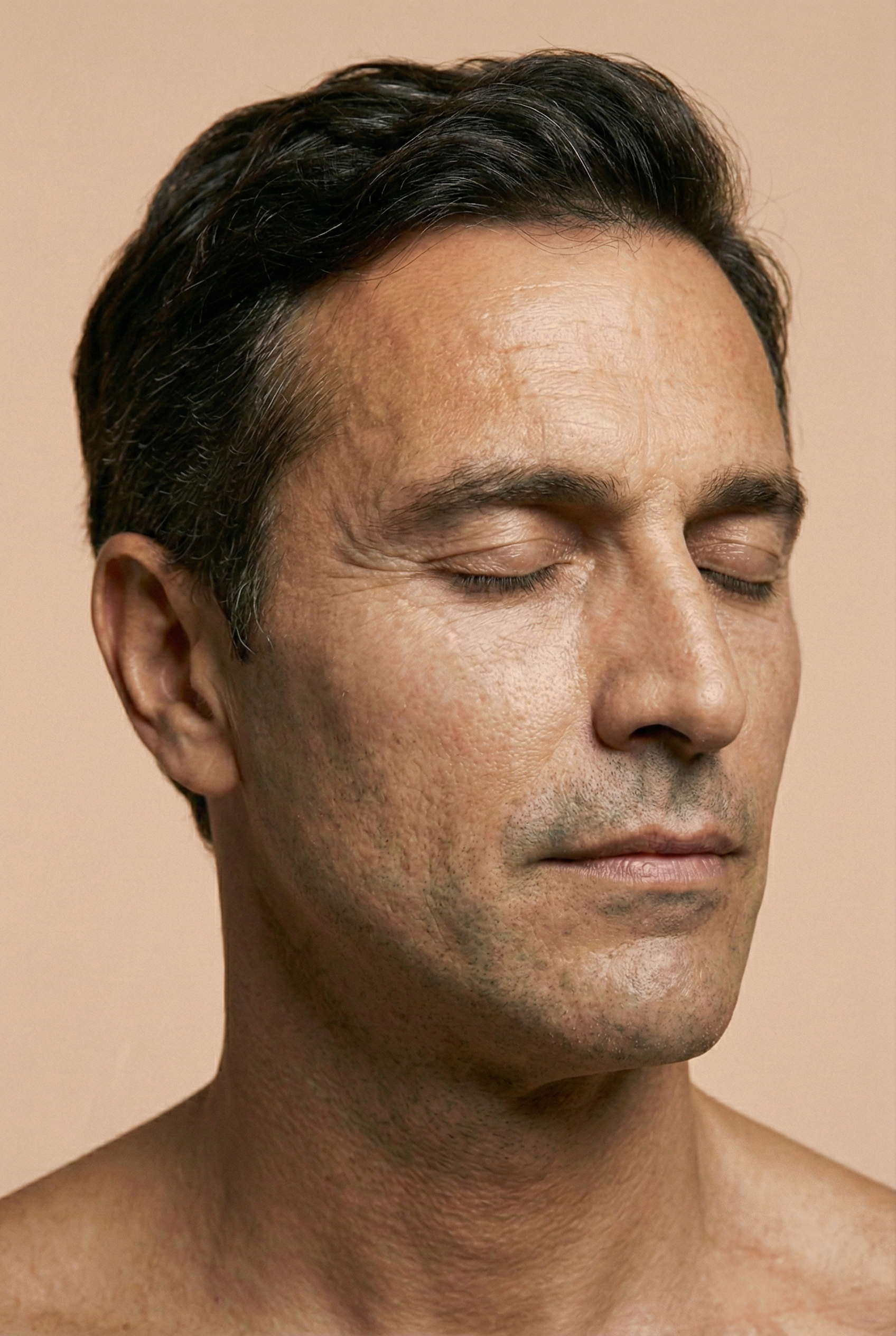 Close-up of a man with dark hair, eyes closed, neutral expression, with visible skin texture and facial details.