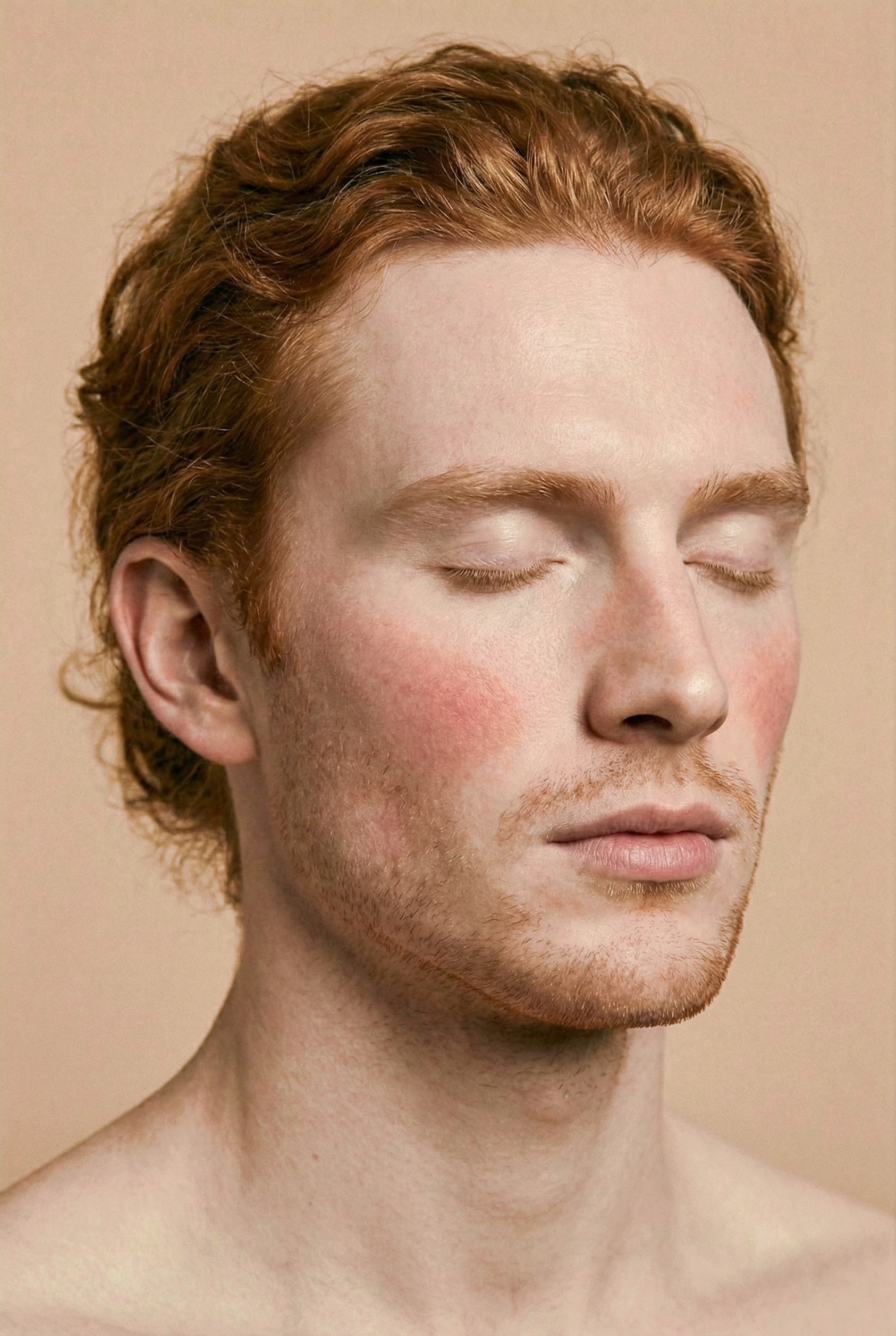 Close-up portrait of a young man with red hair and light skin, with his eyes closed and a calm expression.