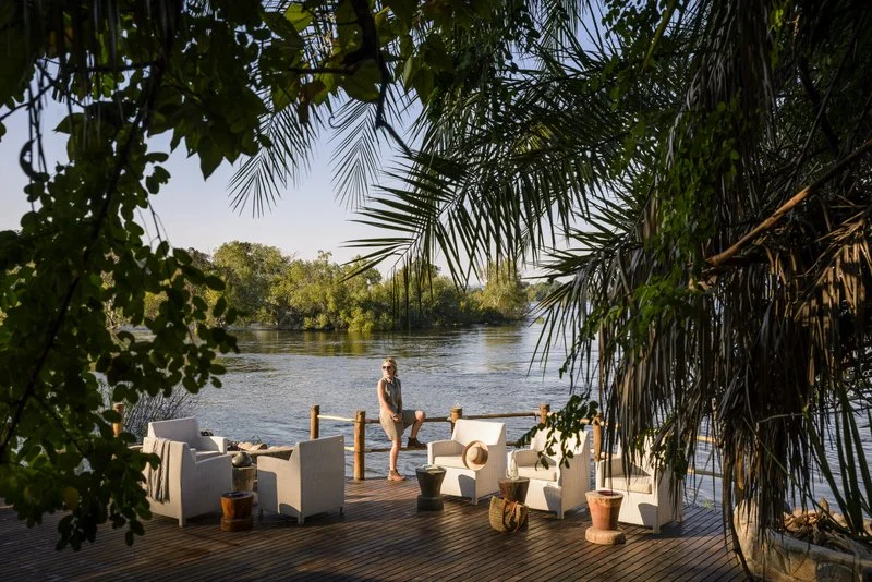 Guest relaxing on a private lodge deck with panoramic views of the Zambezi at Mosi-oa-Tunya, Zambia.