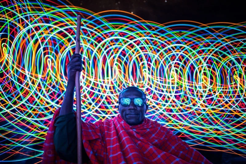 African FootprintsArtistic night photograph of a Maasai guard with a laser light show in the background in Serengeti National Park, Tanzania