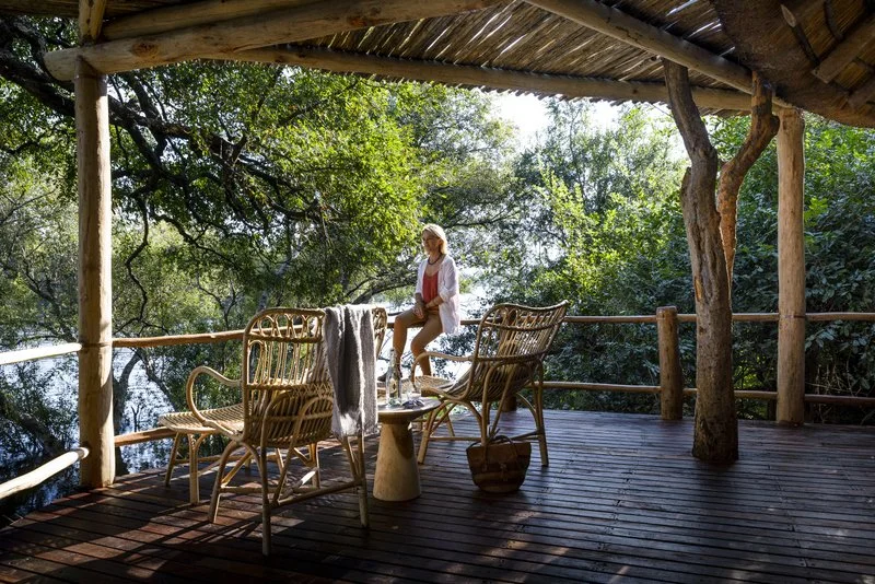 Guest relaxing on a private lodge deck with panoramic views of the Zambezi at Mosi-oa-Tunya, Zambia.