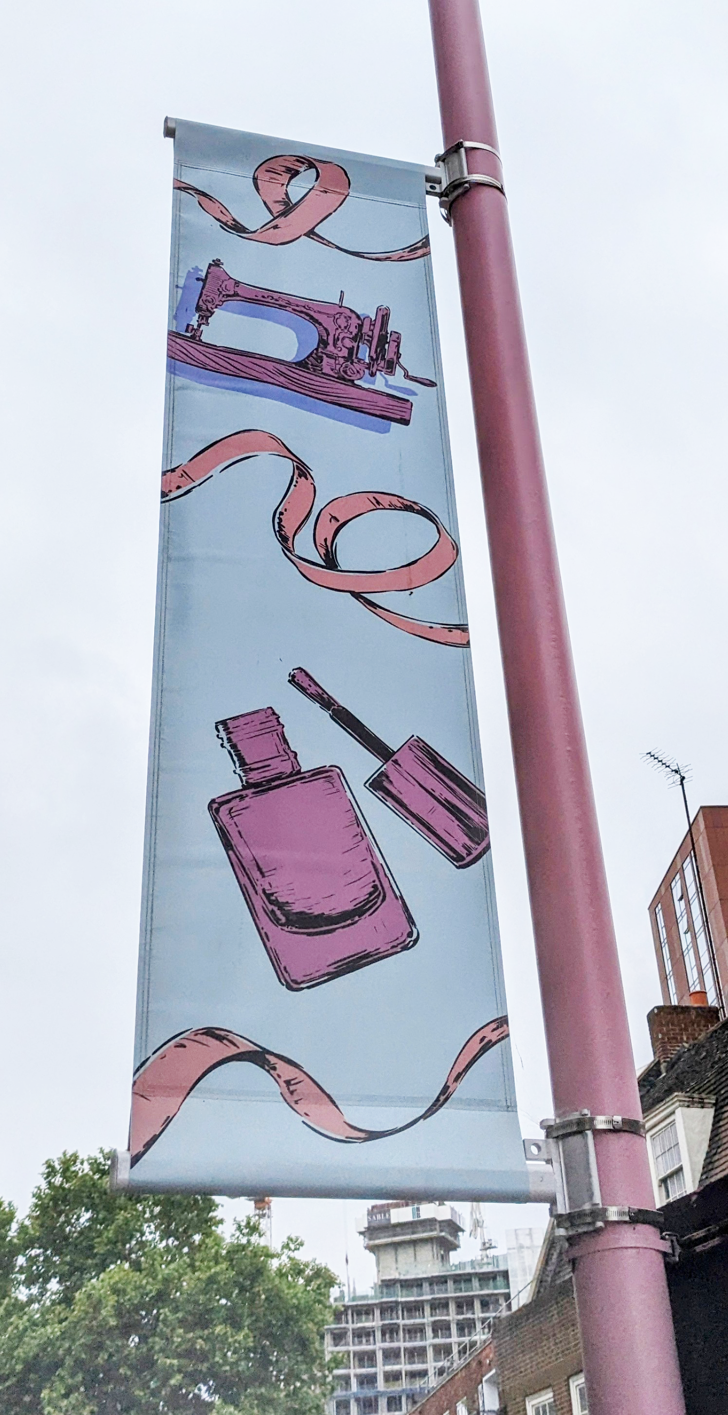 Lamp post banner sign with image of nail varnish and sewing machine