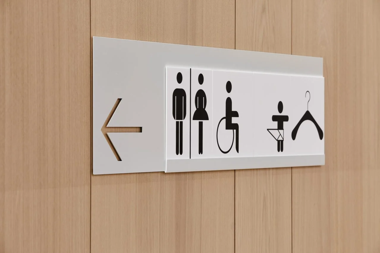 Acrylic toilet signs on light oak panel