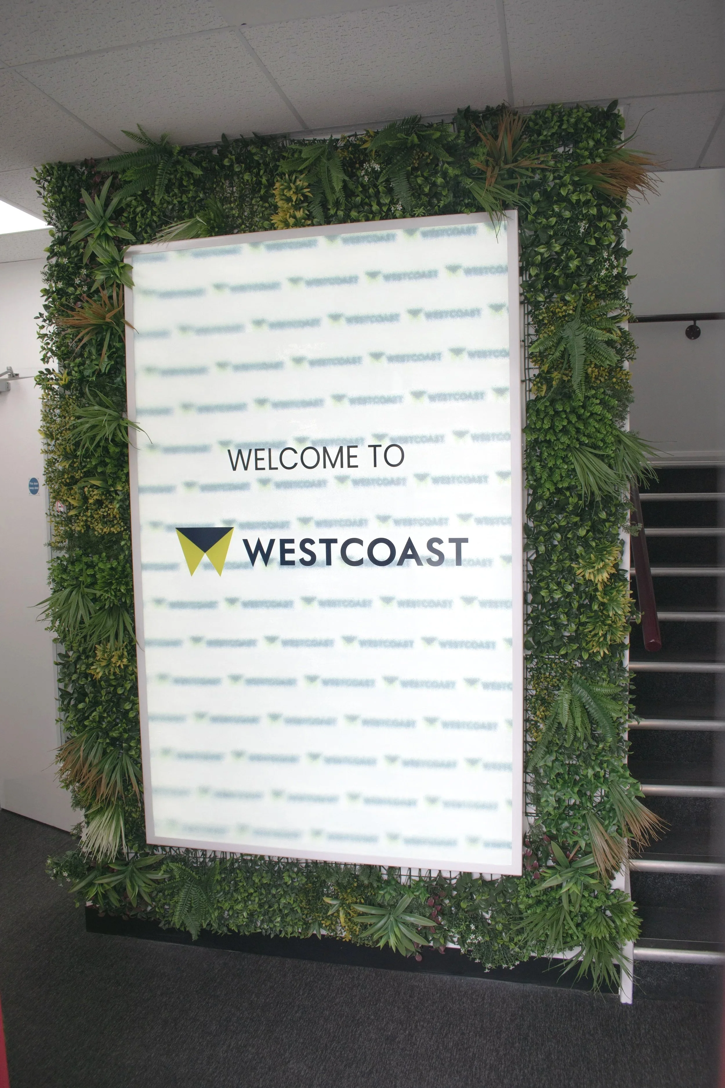 Faux foliage surrounding entrance sign