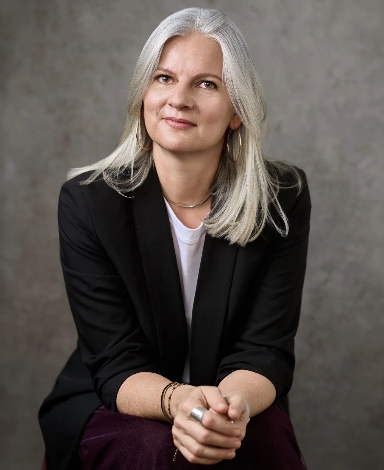 Portrait of Niamh, a female person-centred counsellor, seated and looking at the camera