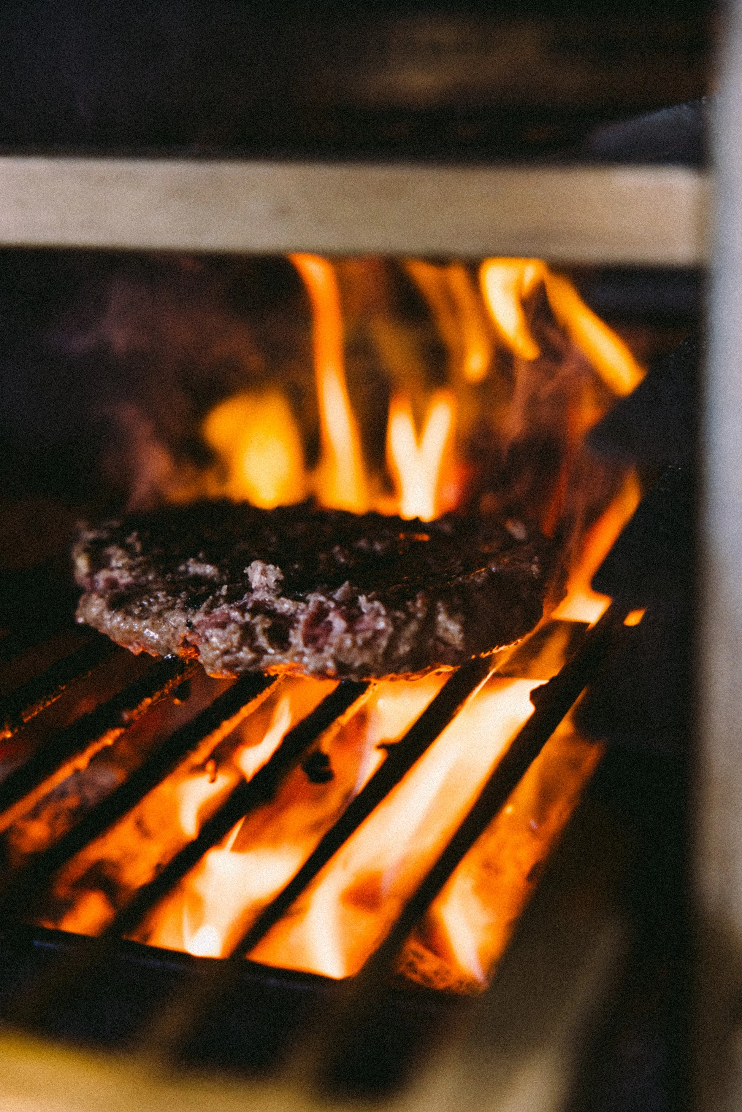 Een hamburger wordt gebakken in een houtskool oven.
