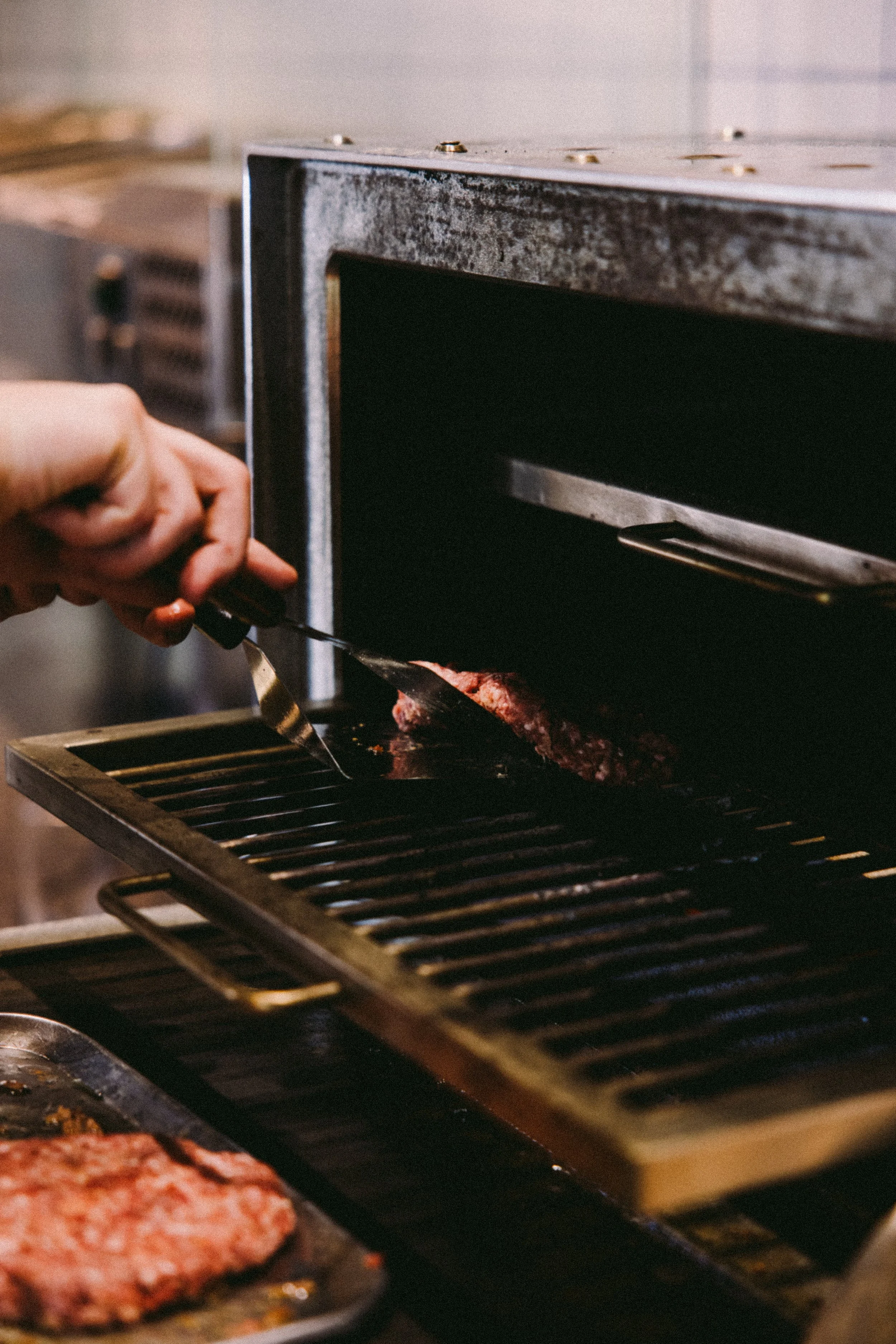 Een hamburger wordt gebakken in een houtskool oven.