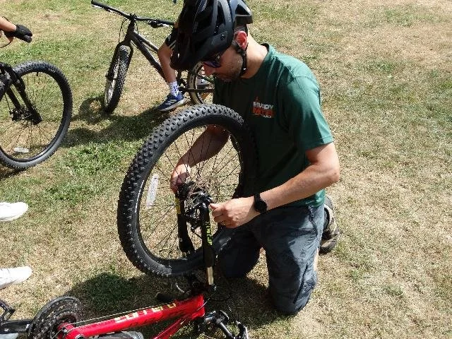 Mountain bike instructor fixing a bike wheel