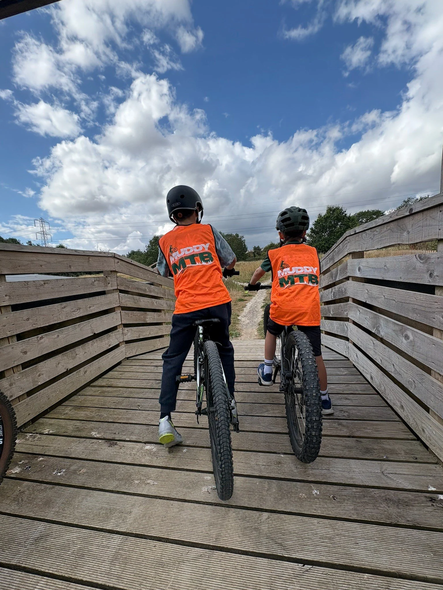 Two boys on a bridge preparing to ride 