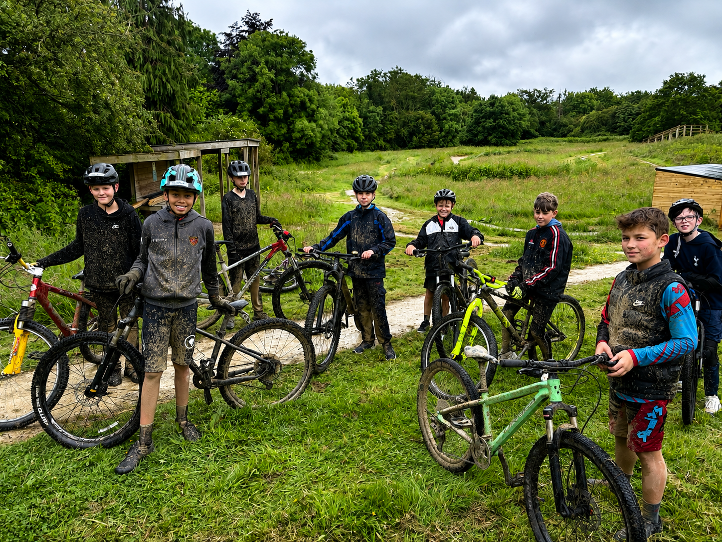 Group of older children muddy after a mountain bike session 