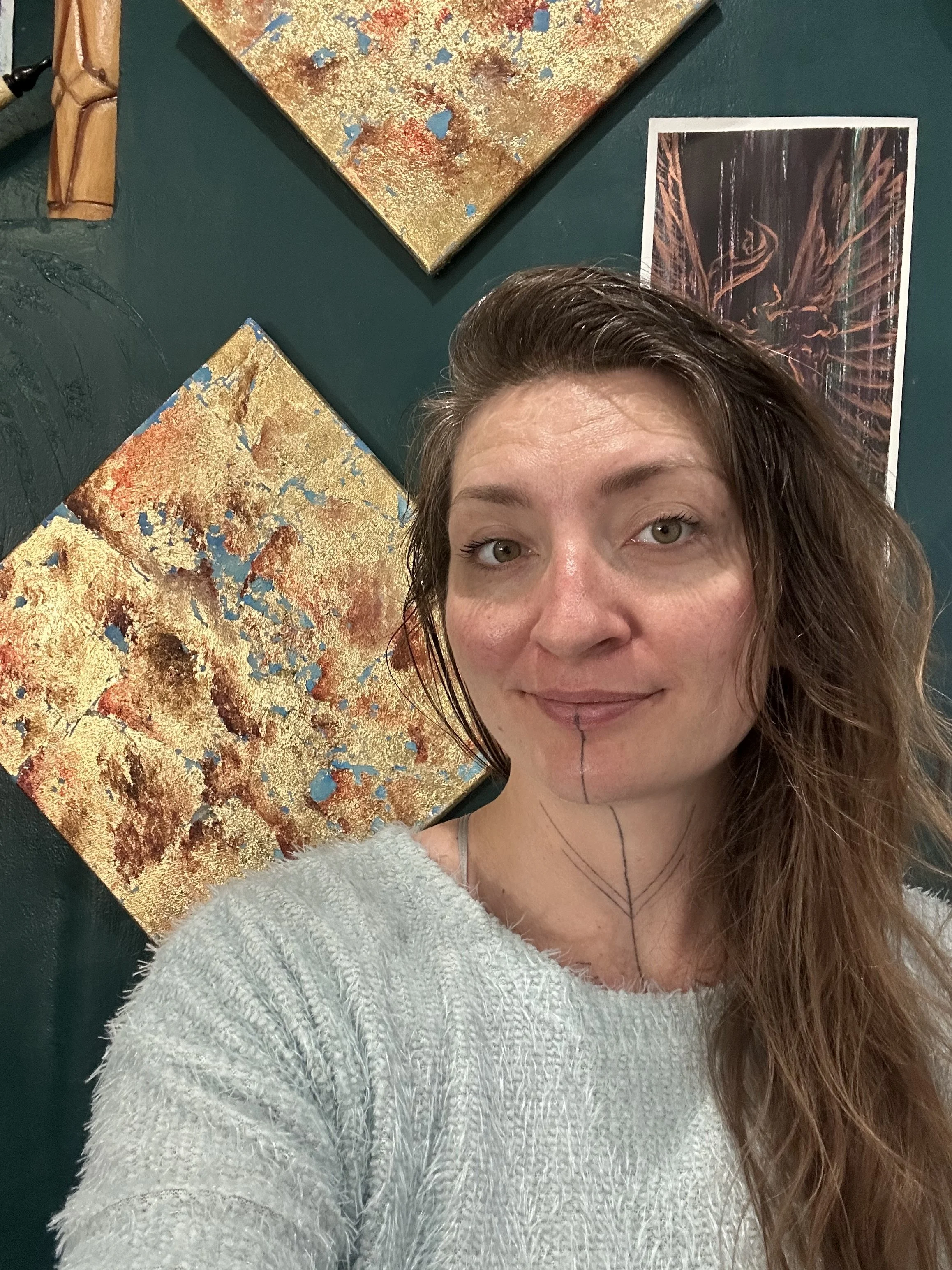 Un portrait d'une tatoueuse à la boutique l’Abeille Bleue au centre-ville de Toulon avec ses tableaux derrière elle prête à l’écoute pour vos projets de tatouage