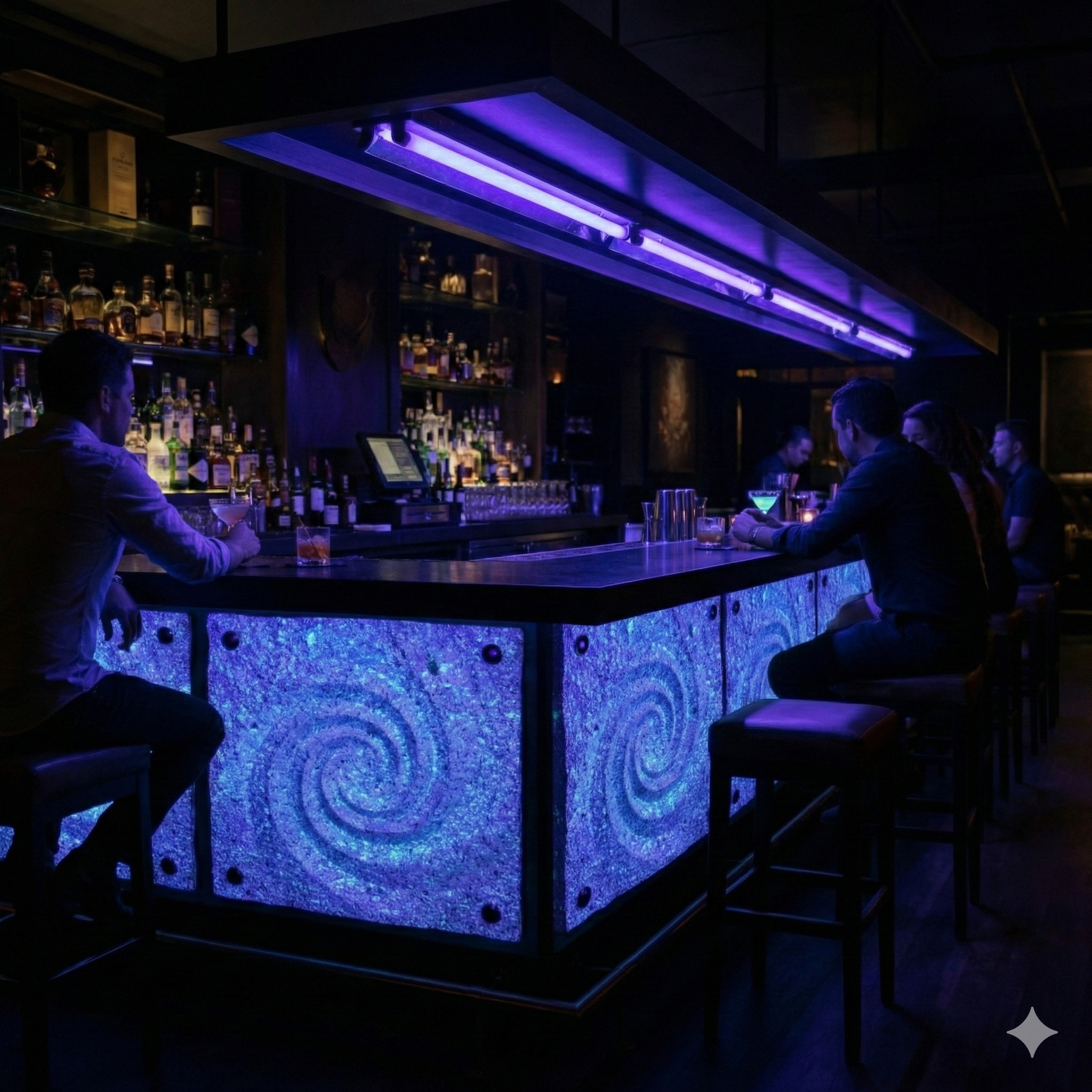 People sitting at a bar with glowing blue decor and liquor bottles on shelves in a dimly lit nightclub.
